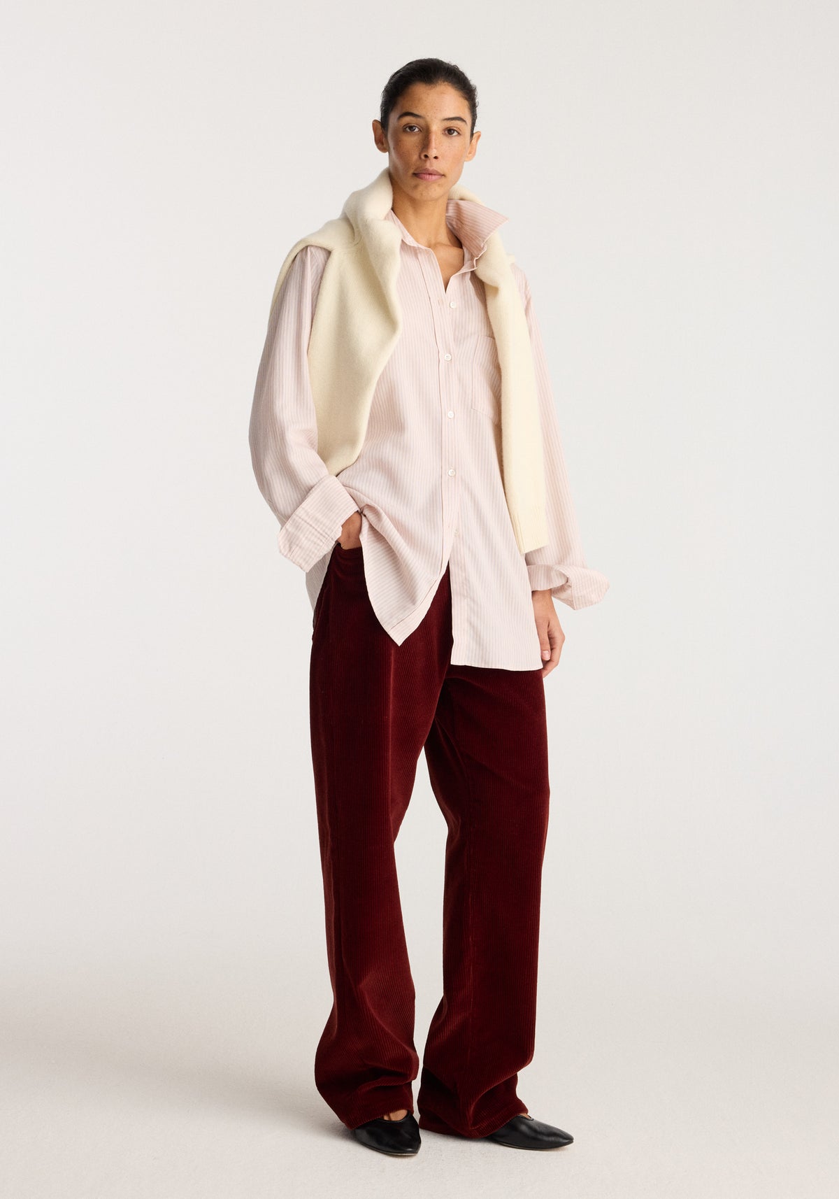 Classic fit striped shirt | rose stripe worn with a cream vest and burgundy trousers on a standing model against a neutral studio background