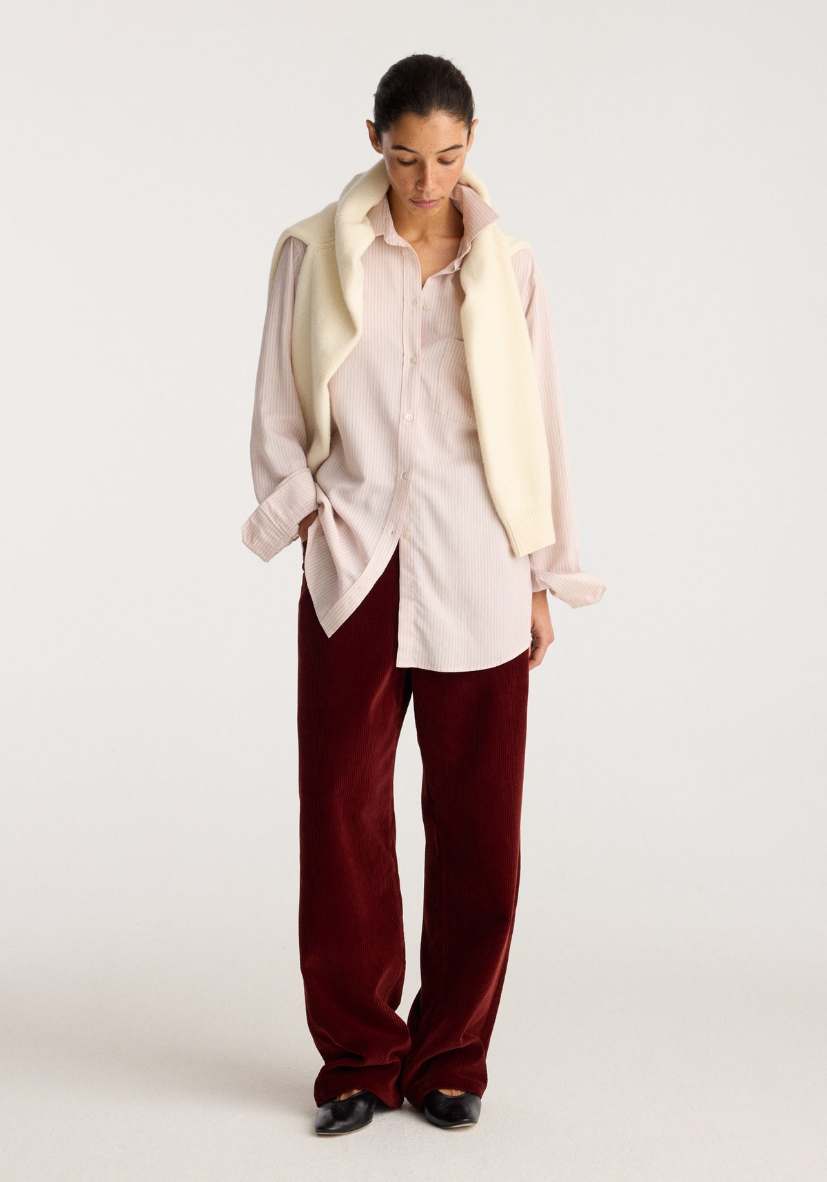 Classic fit striped shirt | rose stripe worn by a model with burgundy trousers and black shoes in a neutral studio setting