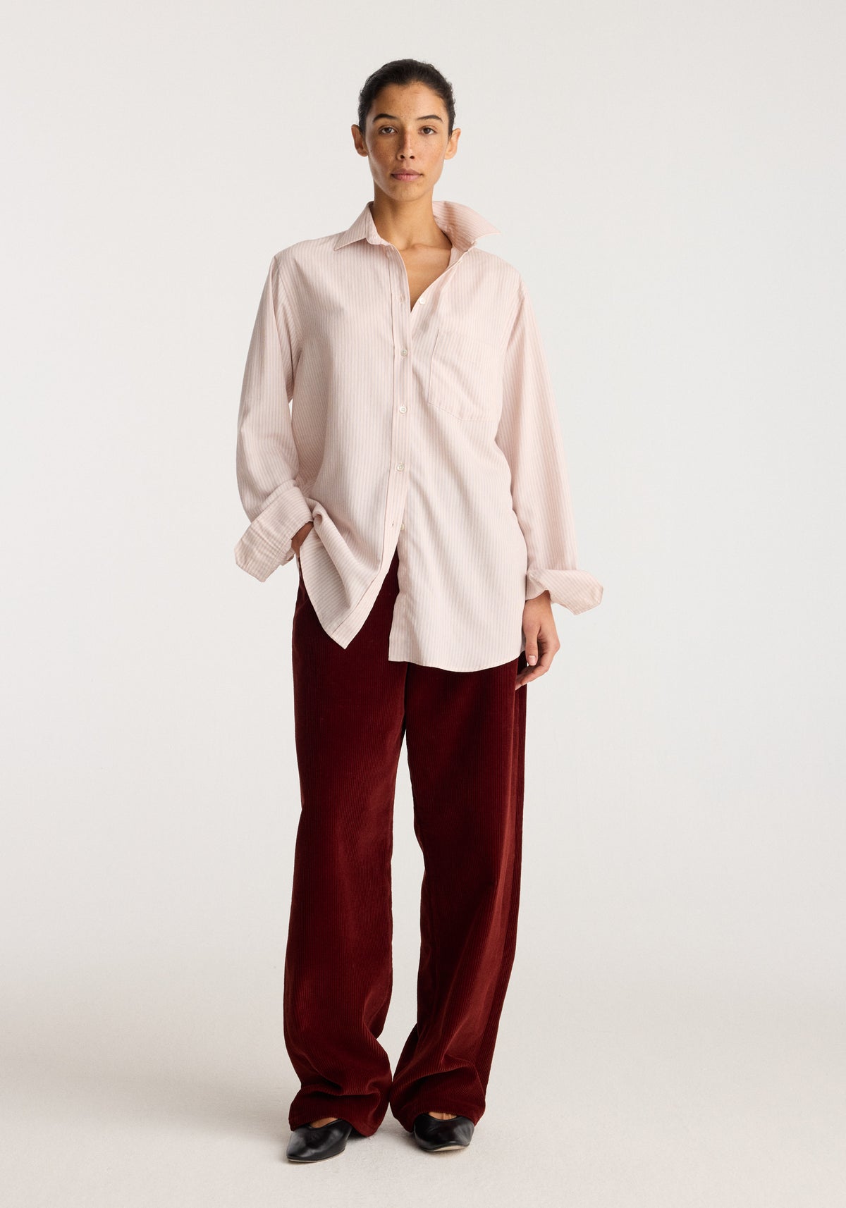 Classic fit striped shirt | rose stripe worn by a model with loose sleeves and button front styled with burgundy trousers and black shoes