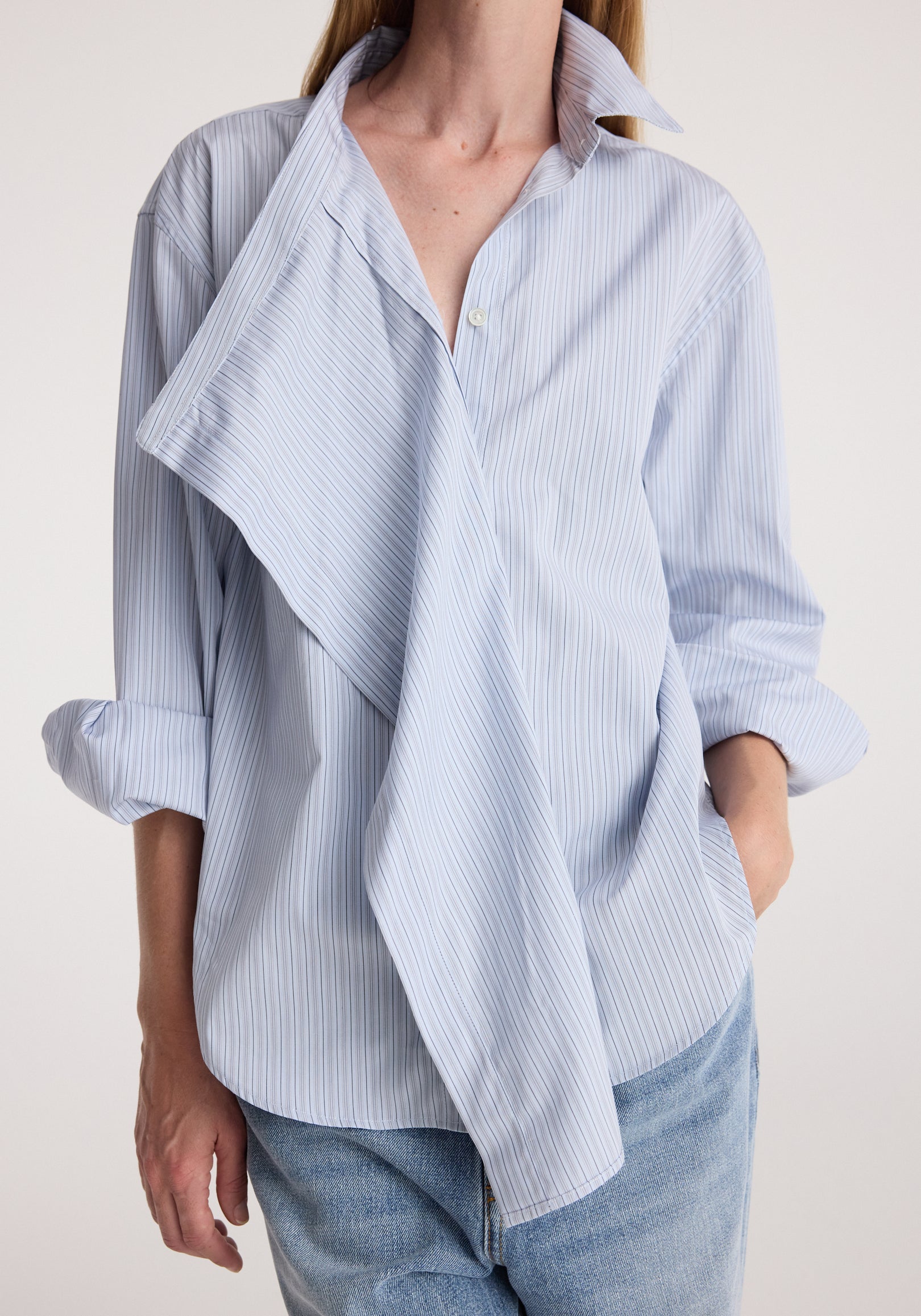 Draped collar shirt | blue stripe worn with rolled sleeves and light wash jeans, featuring a flowing layered front and relaxed fit