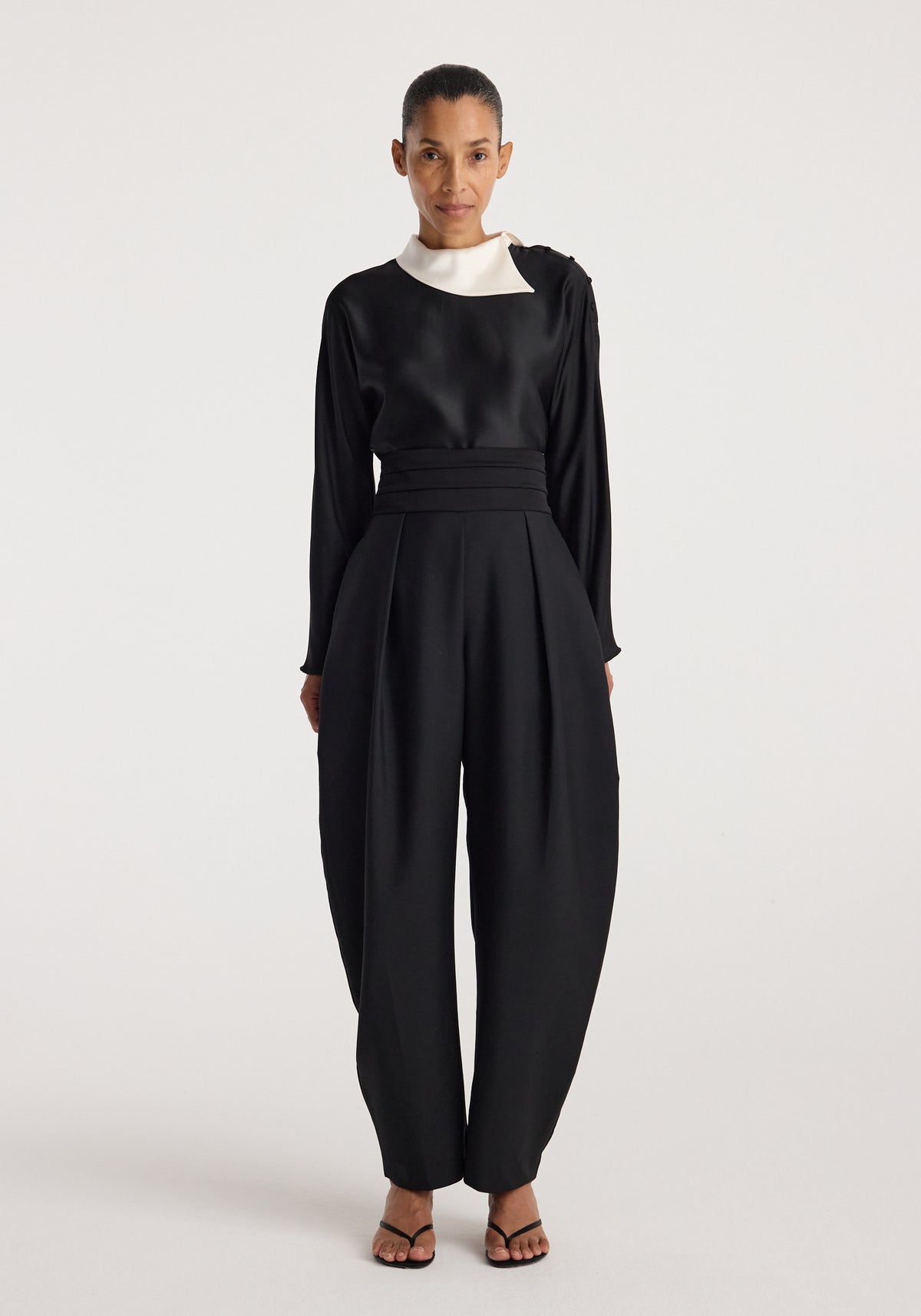 Model wearing Reimagined collar top | black, a black long sleeve top with a contrasting white collar, styled with wide leg trousers and sandals