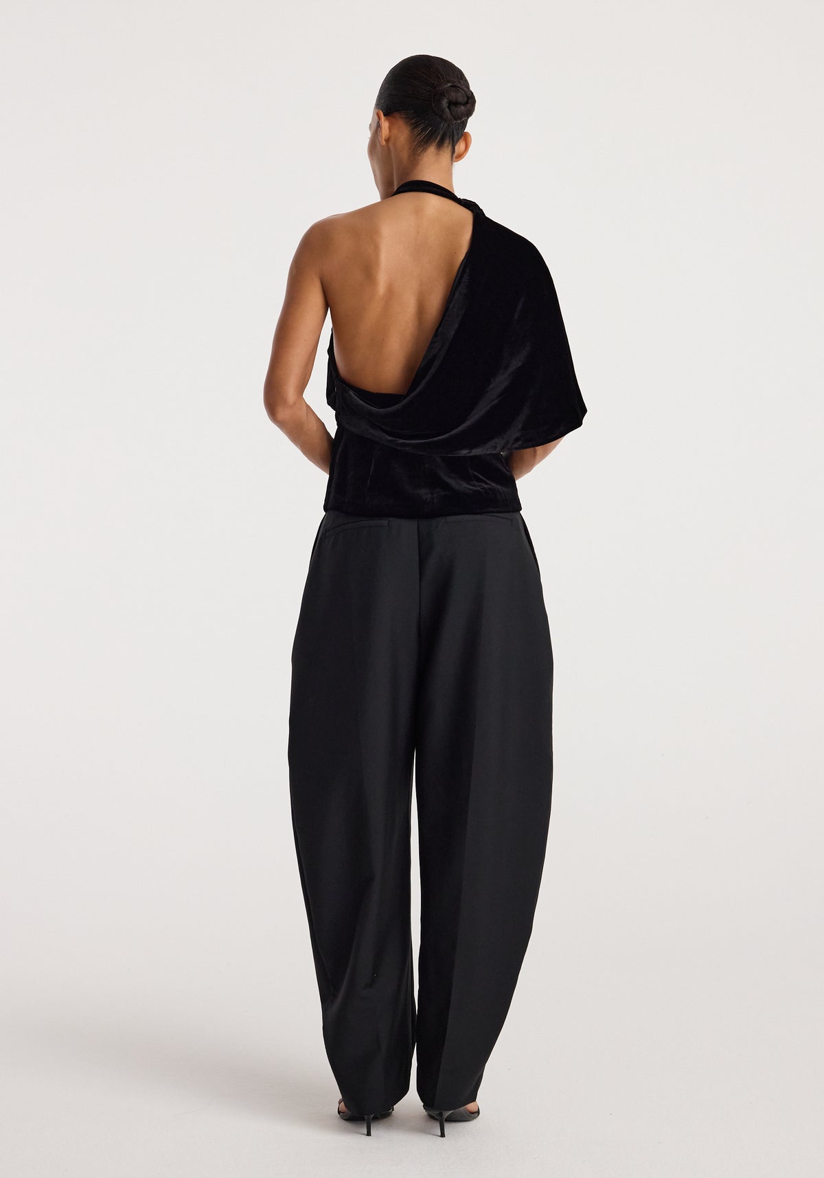 Draped open back silk velvet top | black shown from behind on a model, featuring a deep open back, draped neckline, and relaxed black trousers
