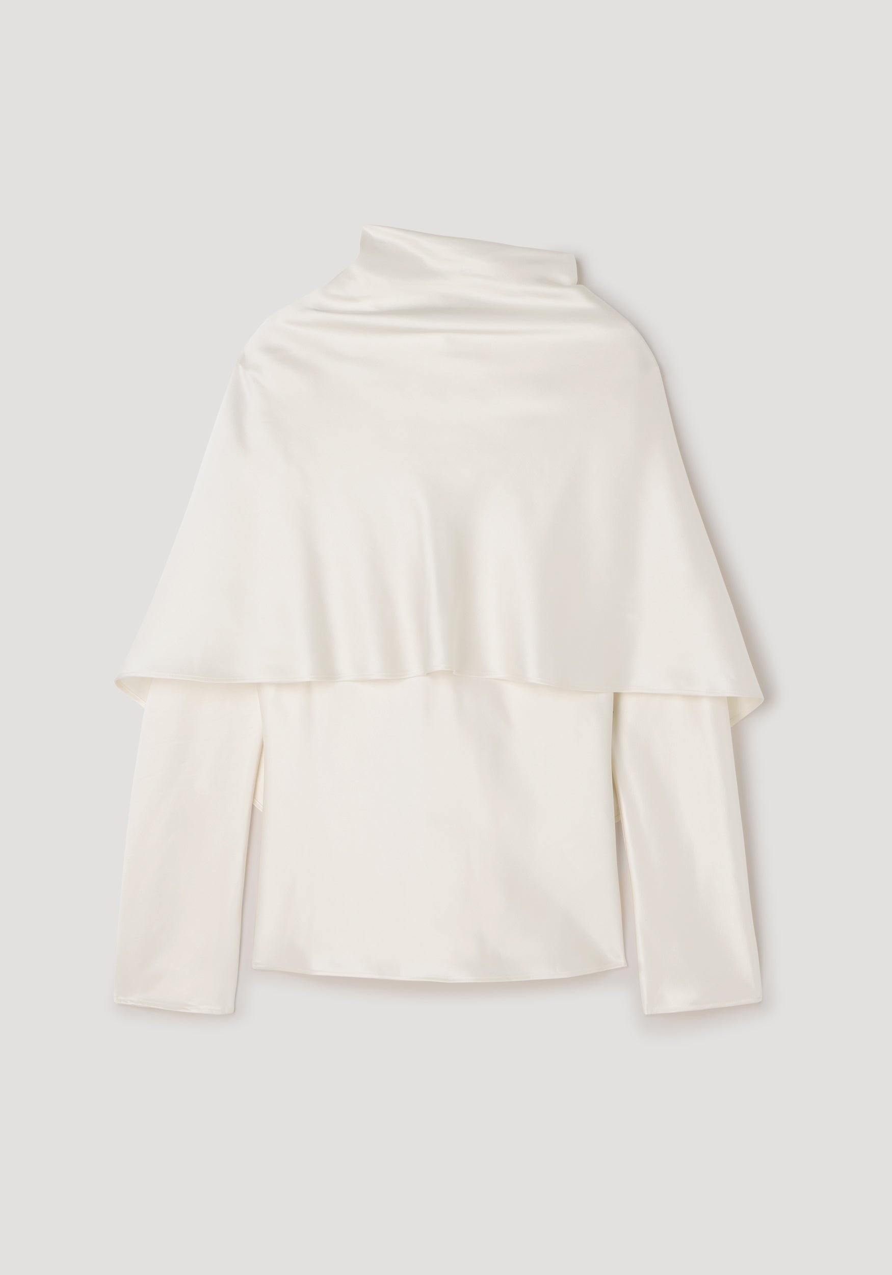 Satin cape top | cream displayed flat, featuring a smooth, shiny satin fabric with a cape overlay draped over long sleeves and a high neckline.