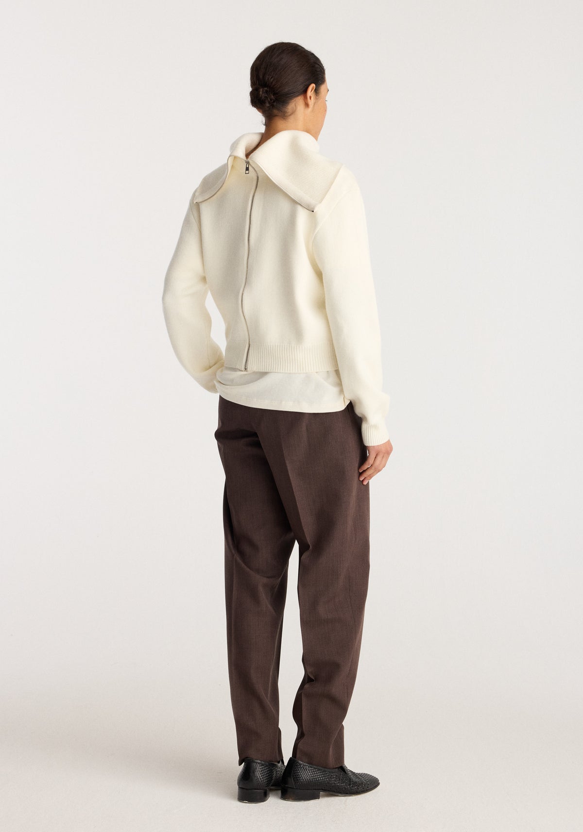 Reversible sailor zip cardigan | cream shown from the back on a model with hood detail and zip closure paired with brown trousers and black shoes