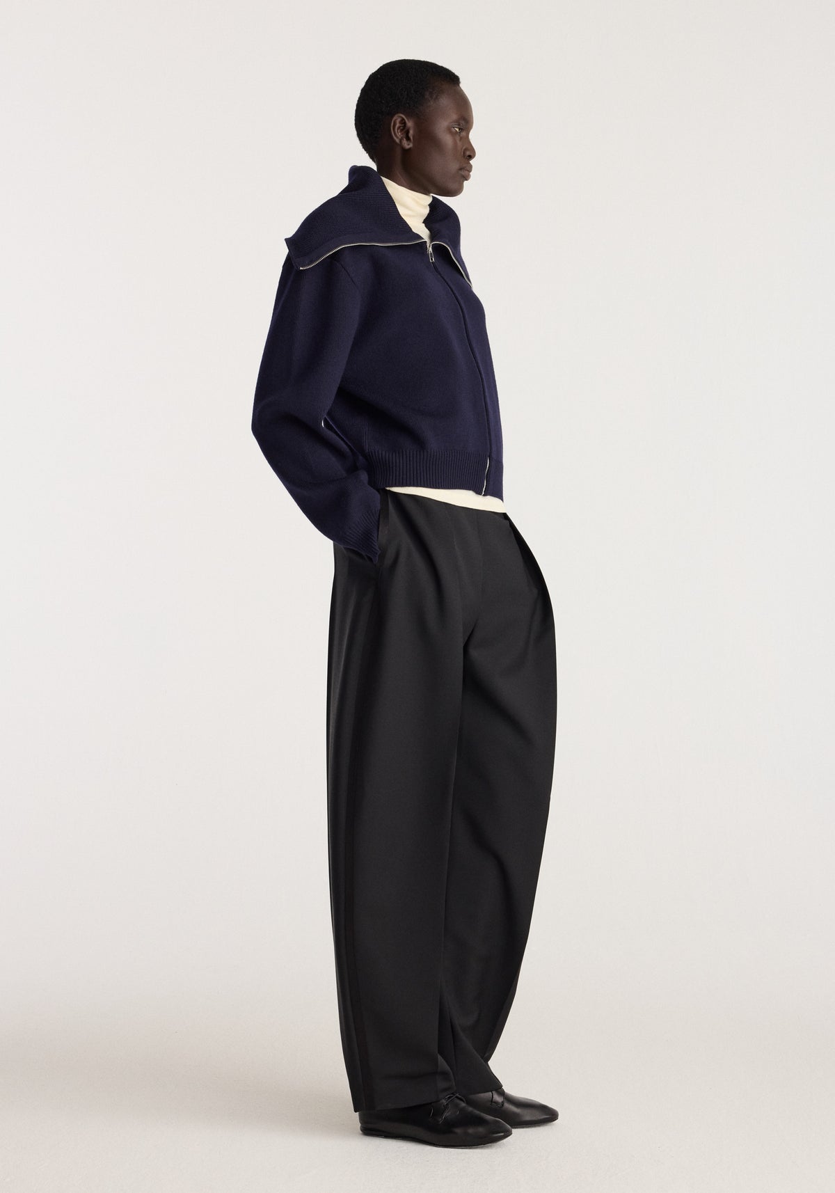 Reversible sailor zip cardigan | navy worn by a model with a high collar and zip front styled with black trousers and black shoes