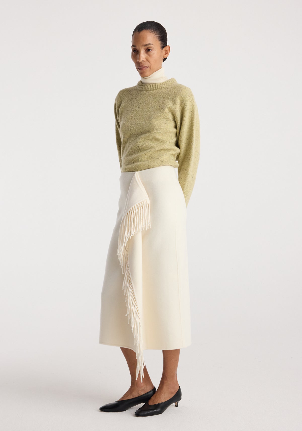 Fitted mouliné crewneck | butter mouliné worn with a cream fringe skirt and black flats by a model in a studio setting