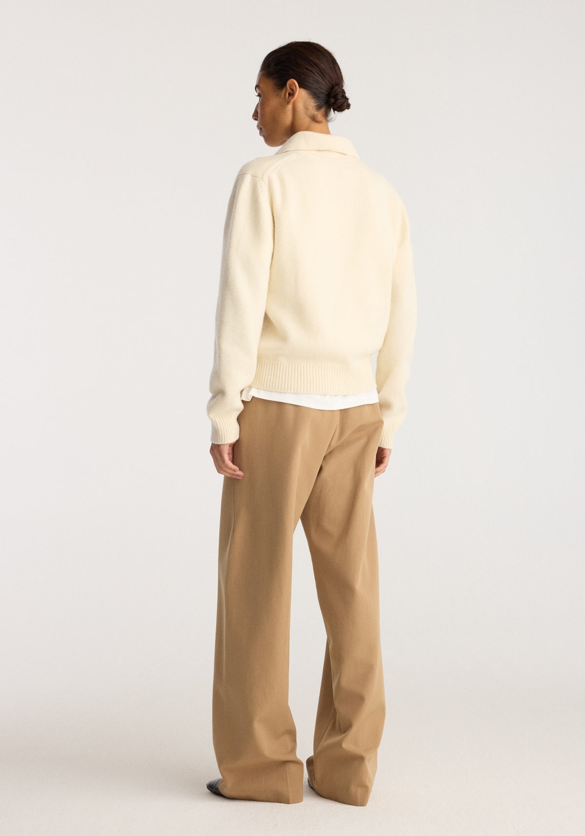 Wool-cashmere polo | cream shown from the back on a model wearing tan trousers against a neutral studio background