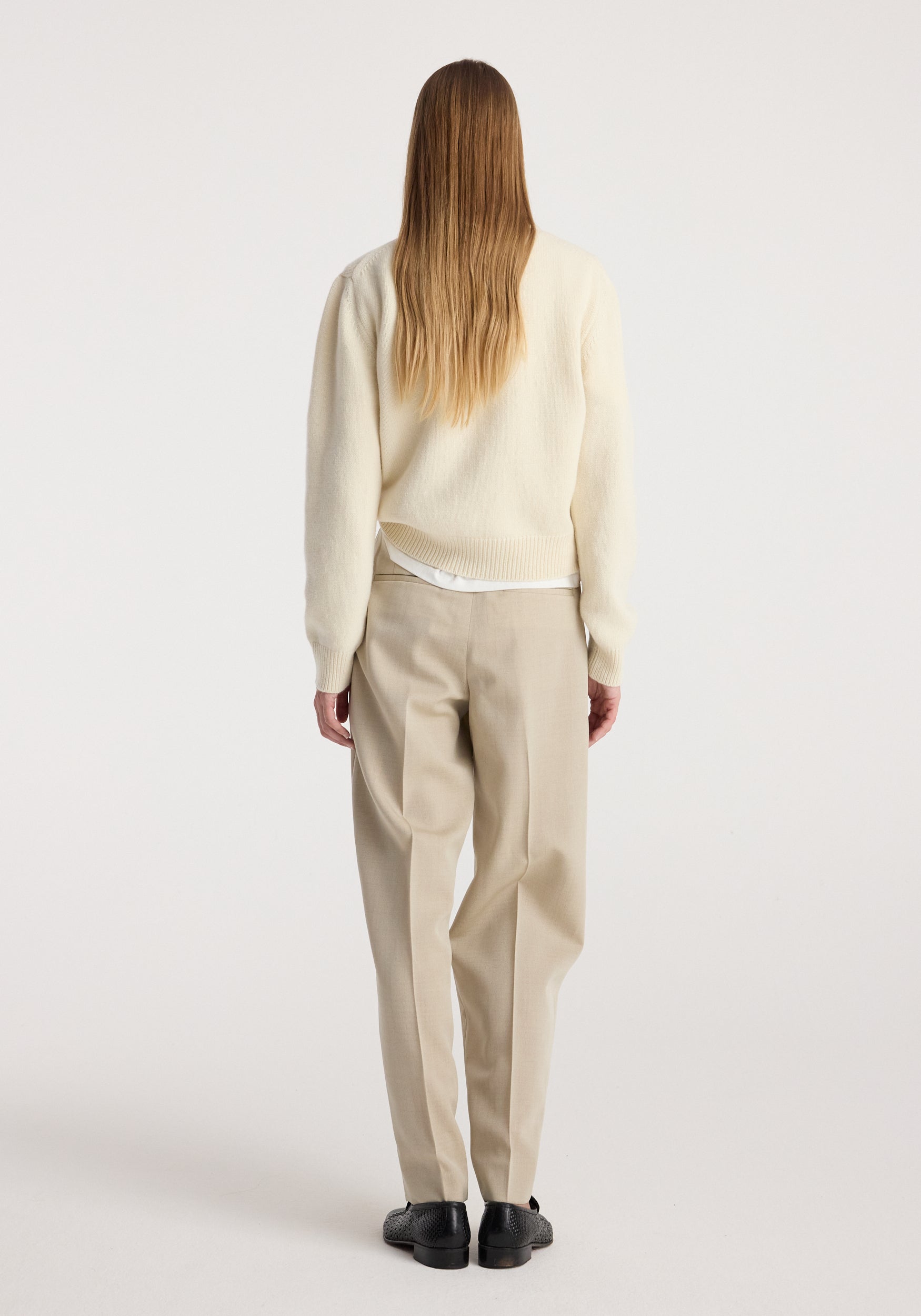 Wool-cashmere polo | cream shown from the back on a model, styled with tailored beige trousers and black loafers against a neutral studio backdrop