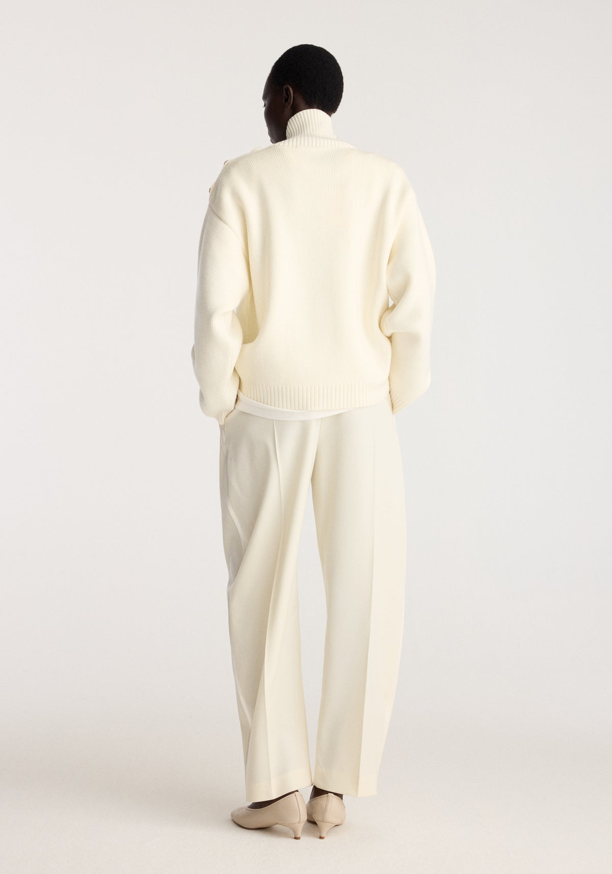 Uneven sailor polo | cream shown from the back on a model with a high collar long sleeves and ribbed hem