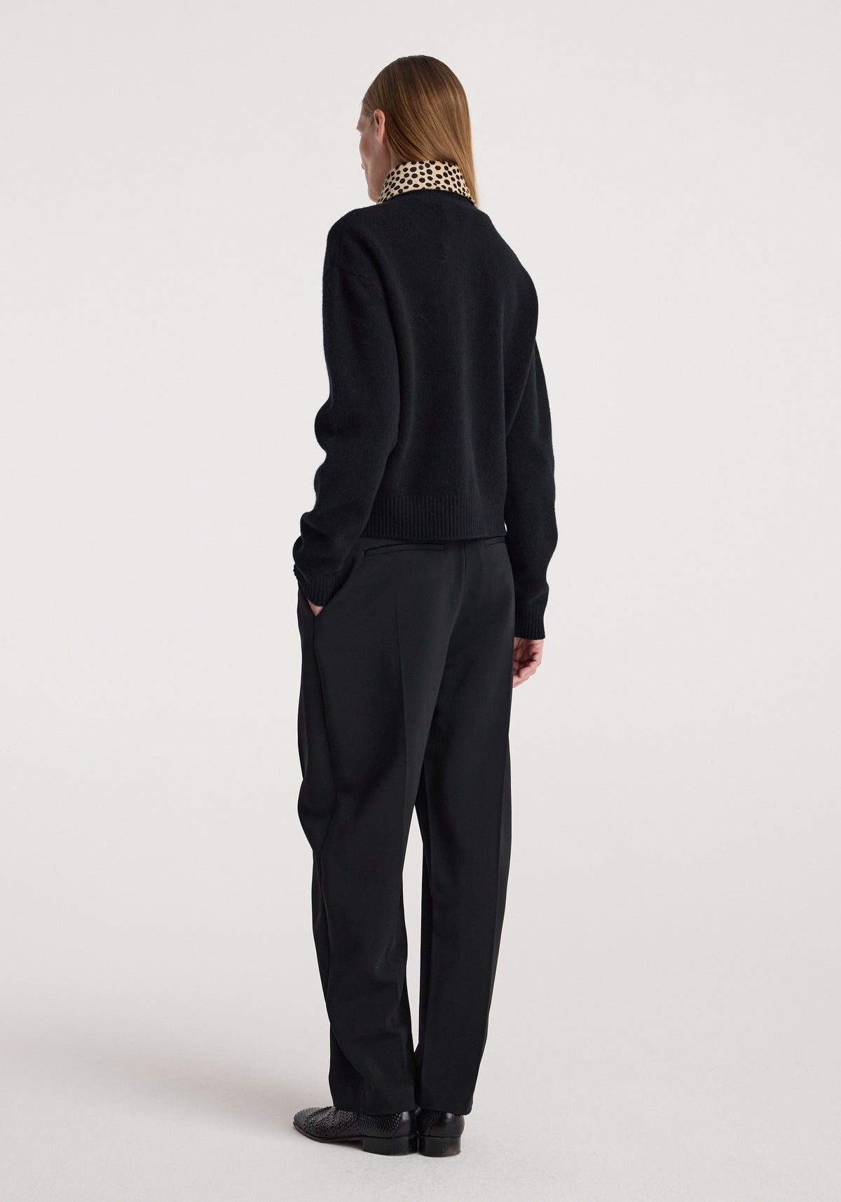 Woman seen from behind wearing a black sweater with a visible cheetah print collar, styled with black pants and black shoes, featuring the Cheetah collar cardigan | black.