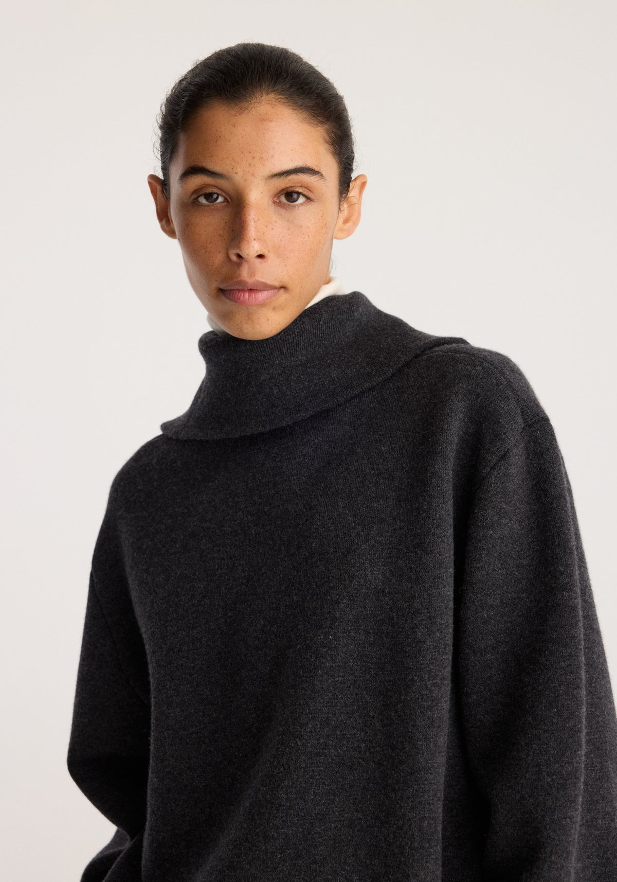 Reversible zipped turtleneck | charcoal worn by a model in a studio with a high neck and long sleeves shown in a relaxed front view