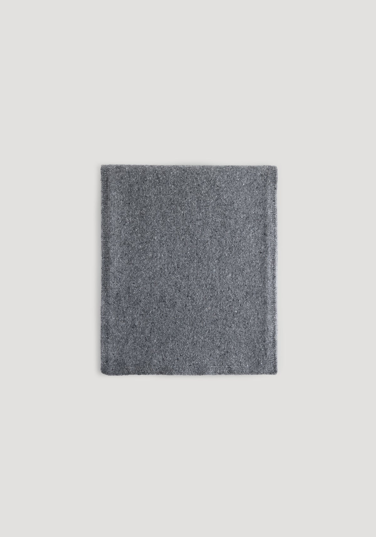 Folded soft textured knitted mouliné scarf in anthracite melange color displayed on a light background, showing its fabric detail and warmth.