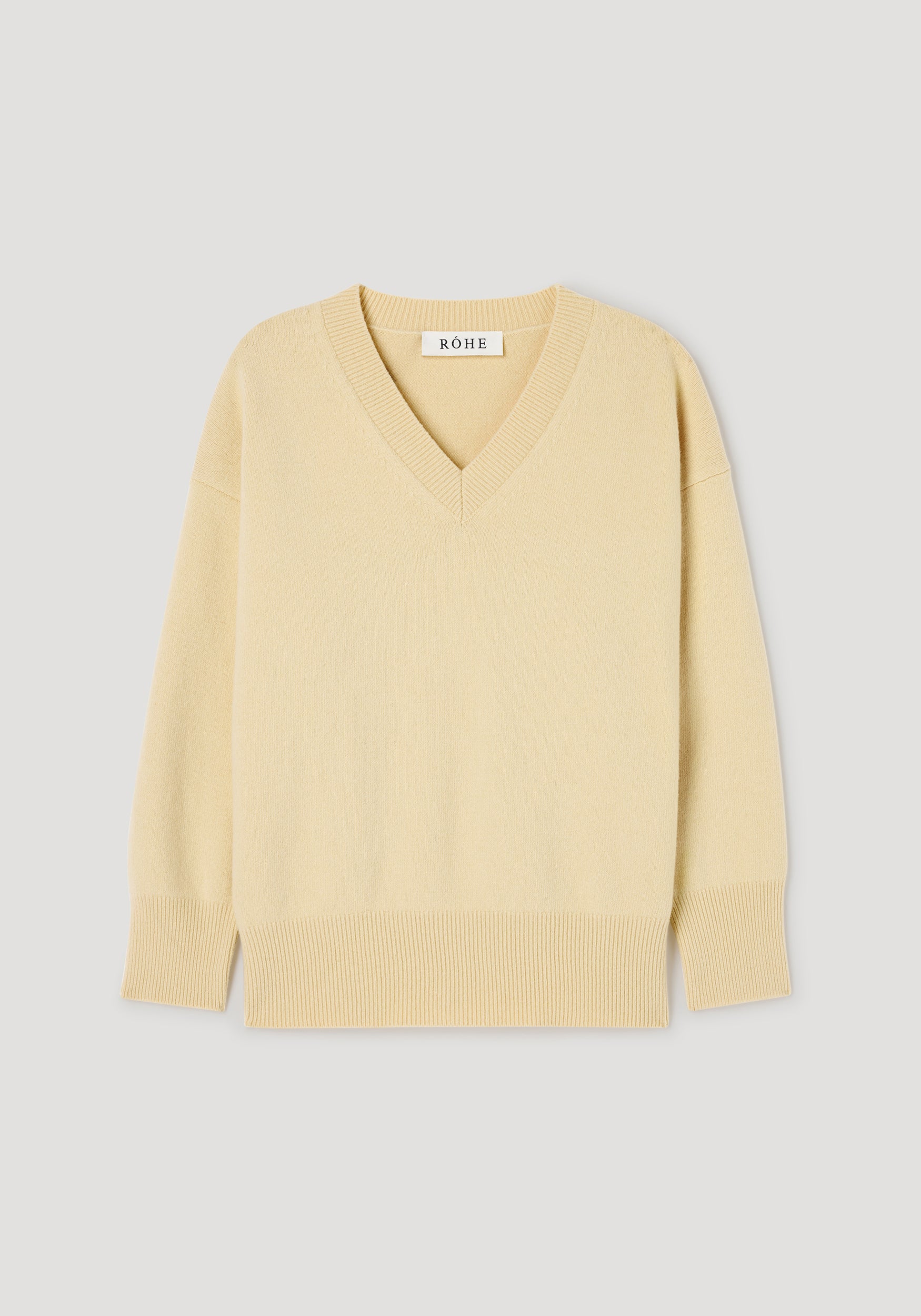 Classic v-neck jumper | butter in a soft yellow shade, featuring long sleeves, ribbed cuffs, and hem, displayed flat on a light background.