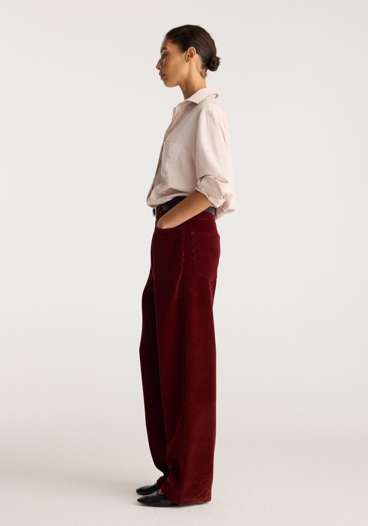 Bruun - Signature baggy corduroy trousers | wine shown on a model in side profile with a pale shirt and black shoes