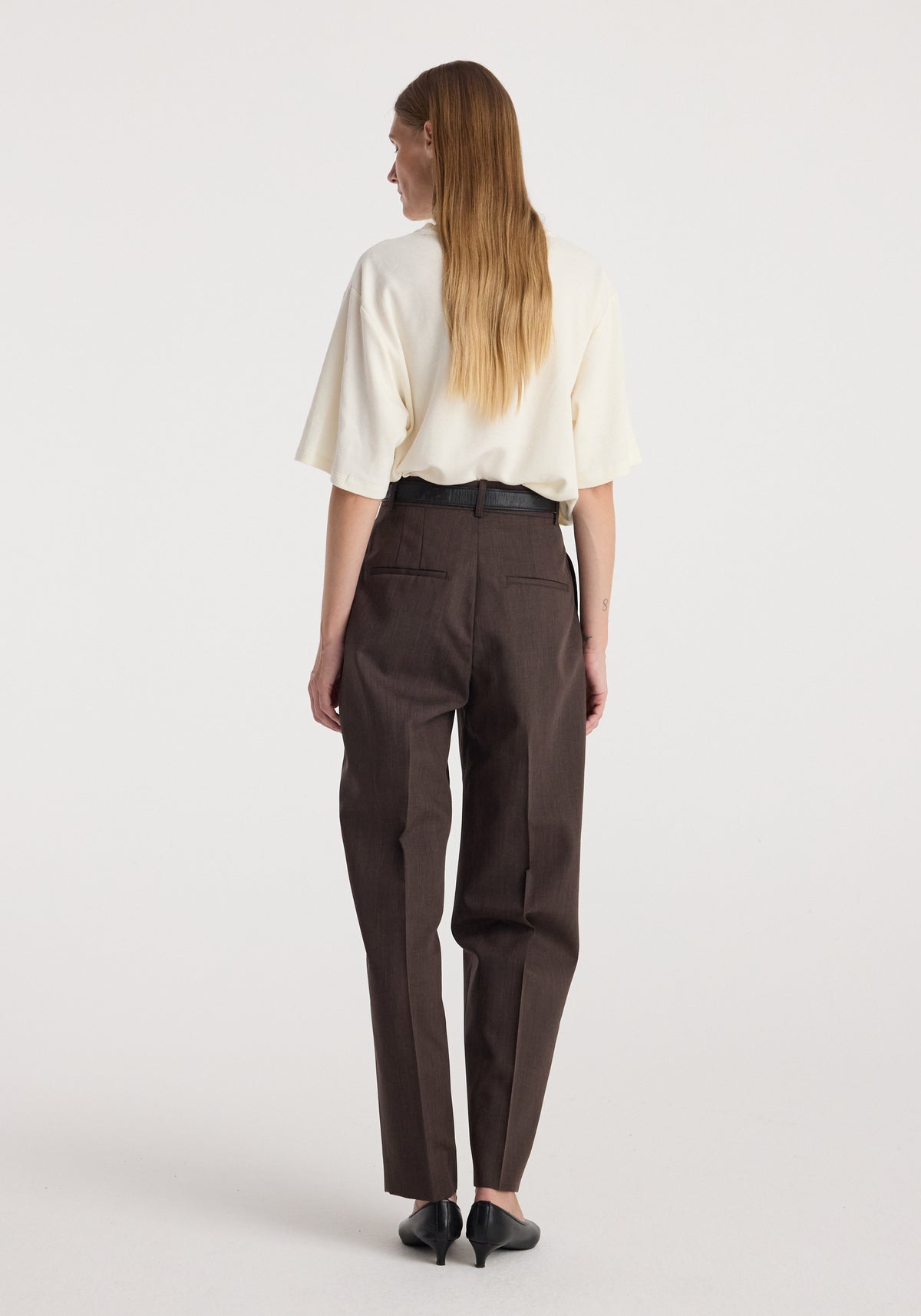 Daria - Single pleat straight leg trousers | dark brown shown from behind on a model with a cream blouse and pointed shoes