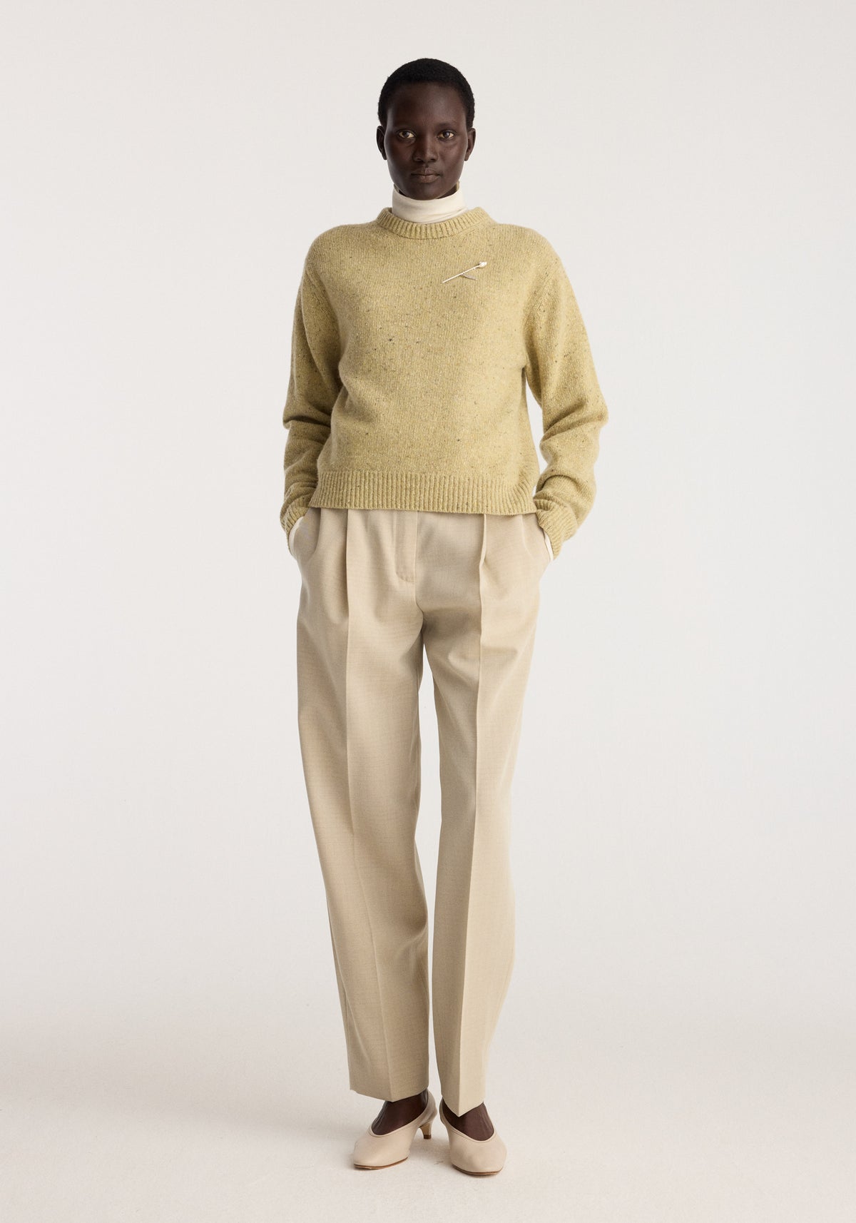 Daria - Single pleat straight leg trousers | butter worn by a model with a sweater and loafers in a studio setting