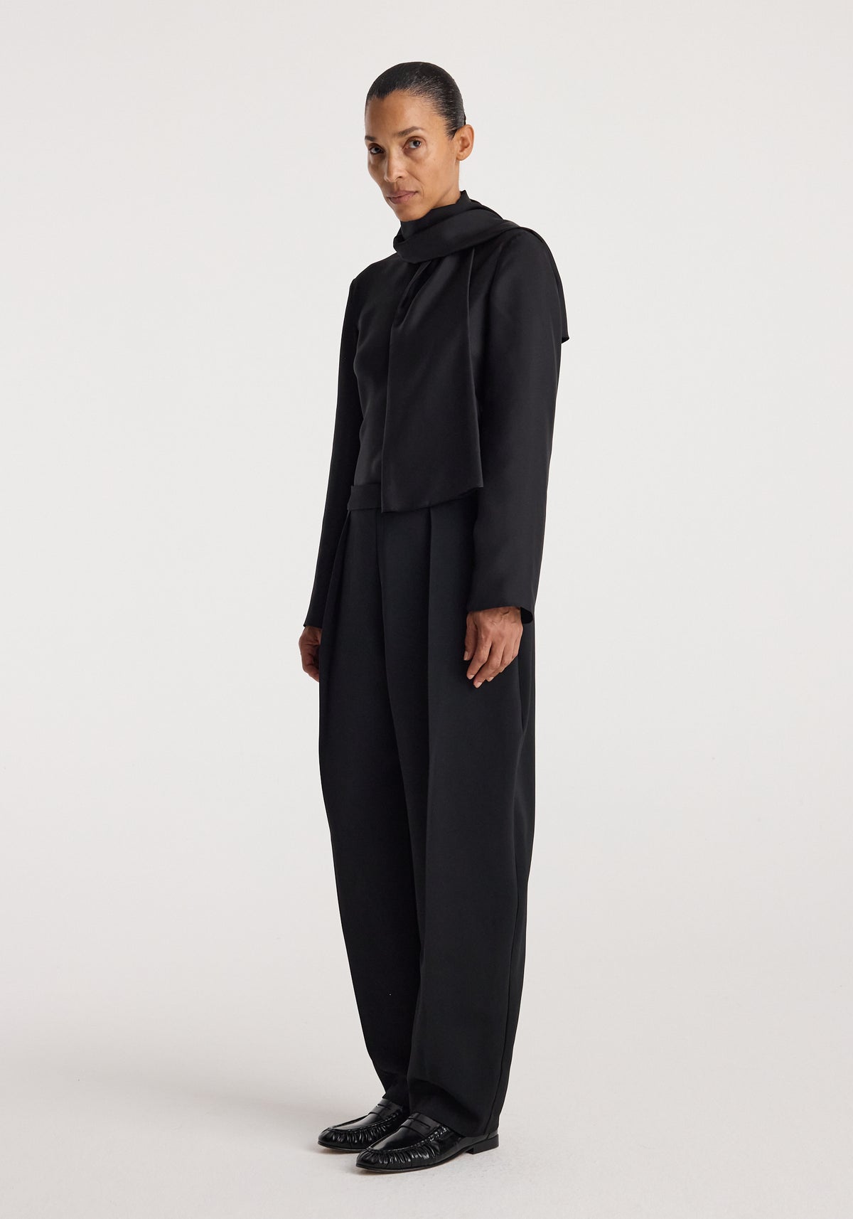 Puck - Sculptural tailored trousers | black worn by a model in a full-length studio portrait, styled with a black top and polished black shoes