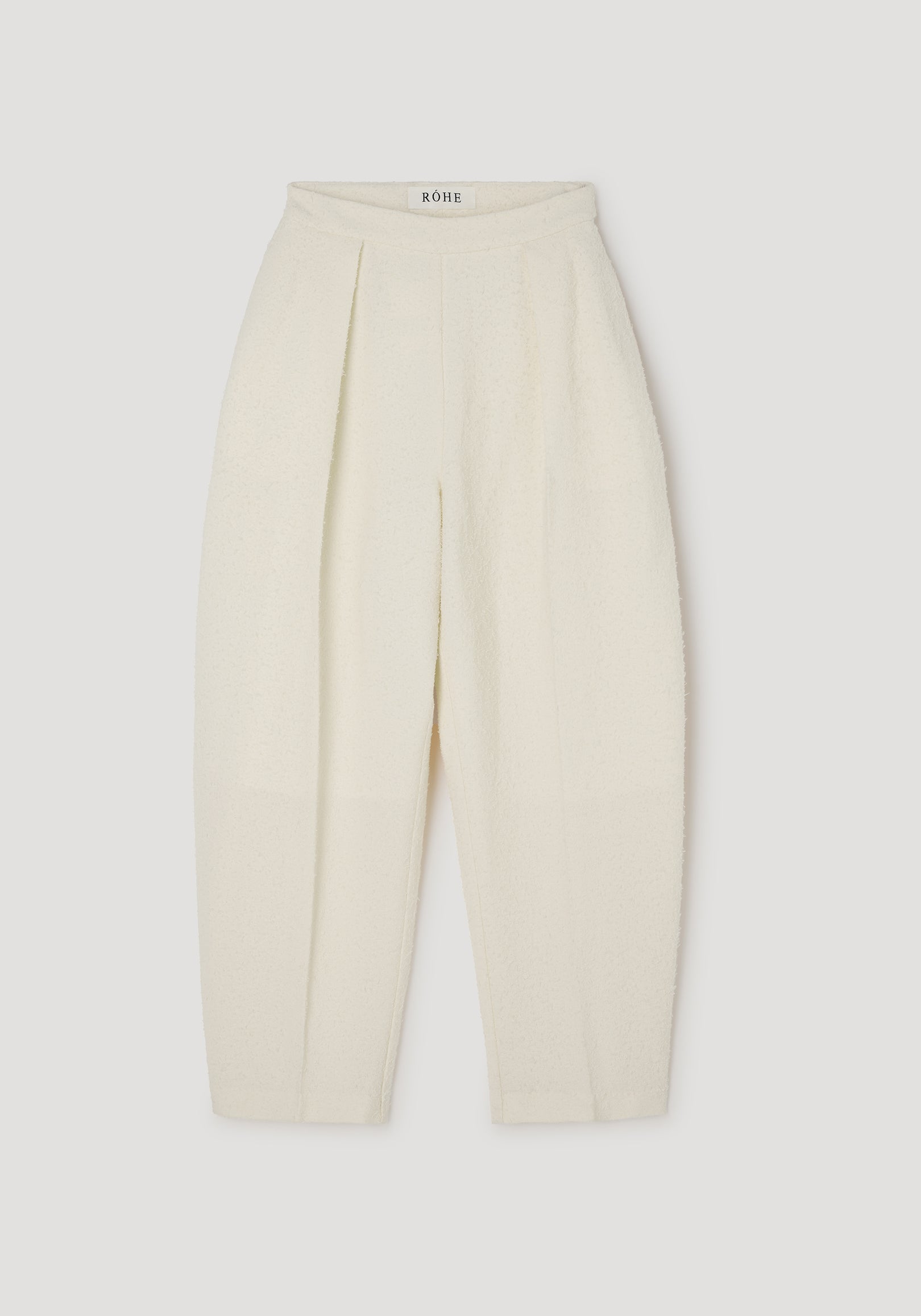 Puck - Sculptural bouclé tailored trousers | cream displayed flat, featuring a high waist, pleated front, and textured fabric in a soft cream color.