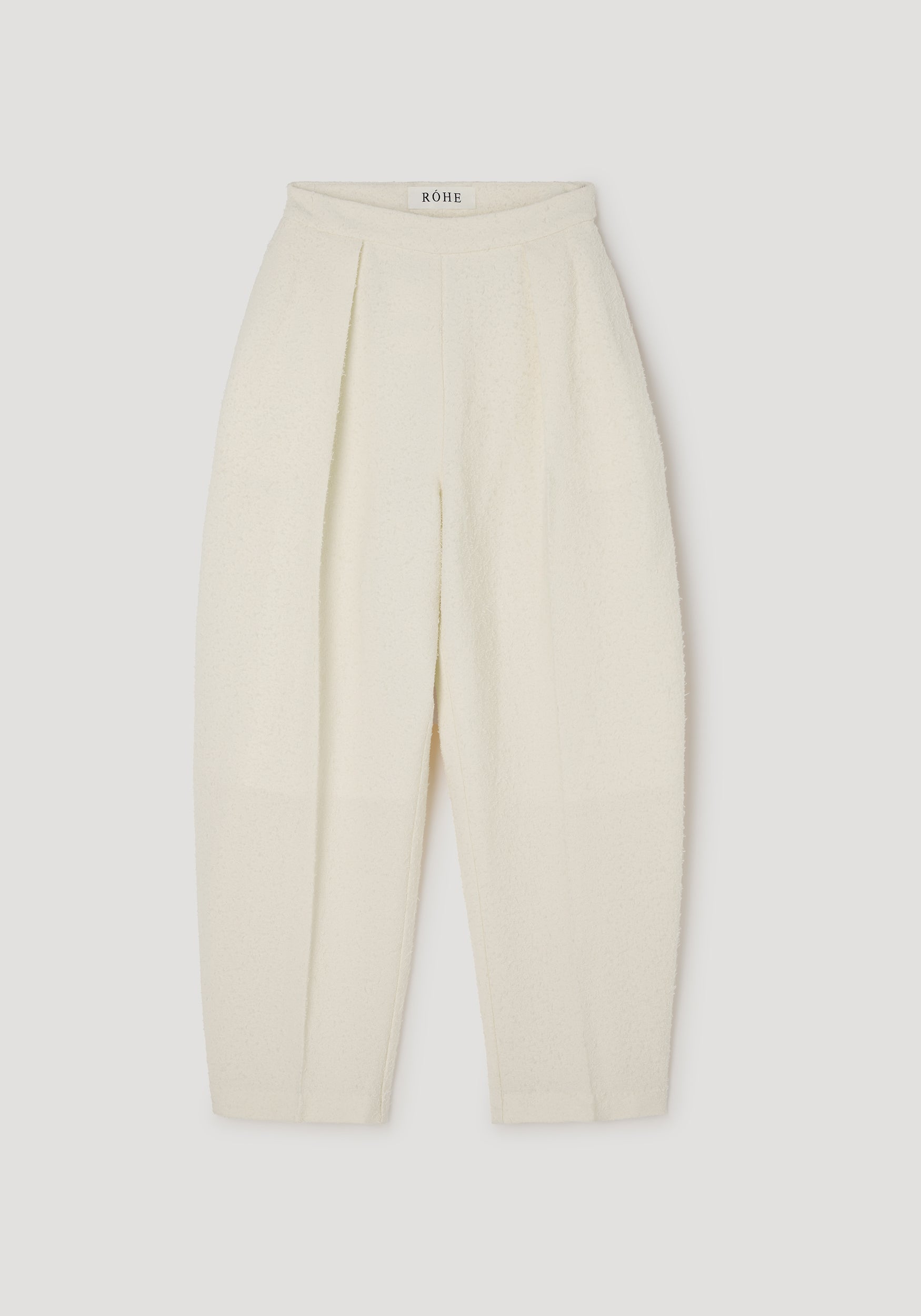 Puck - Sculptural bouclé tailored trousers | cream displayed flat, featuring a high waist, pleated front, and textured fabric in a soft cream color.
