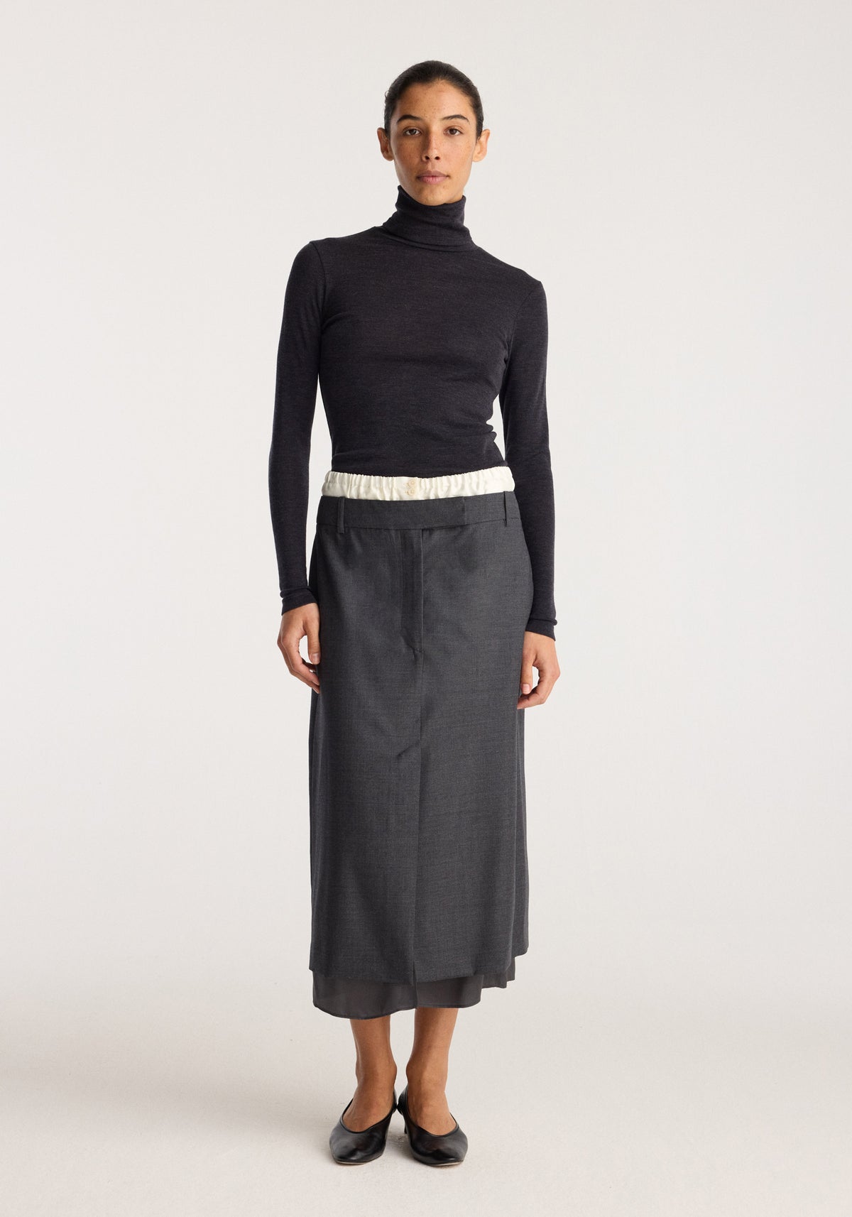 Boxer detailed skirt | dark grey melange worn with a black turtleneck top and black flats on a model against a light background