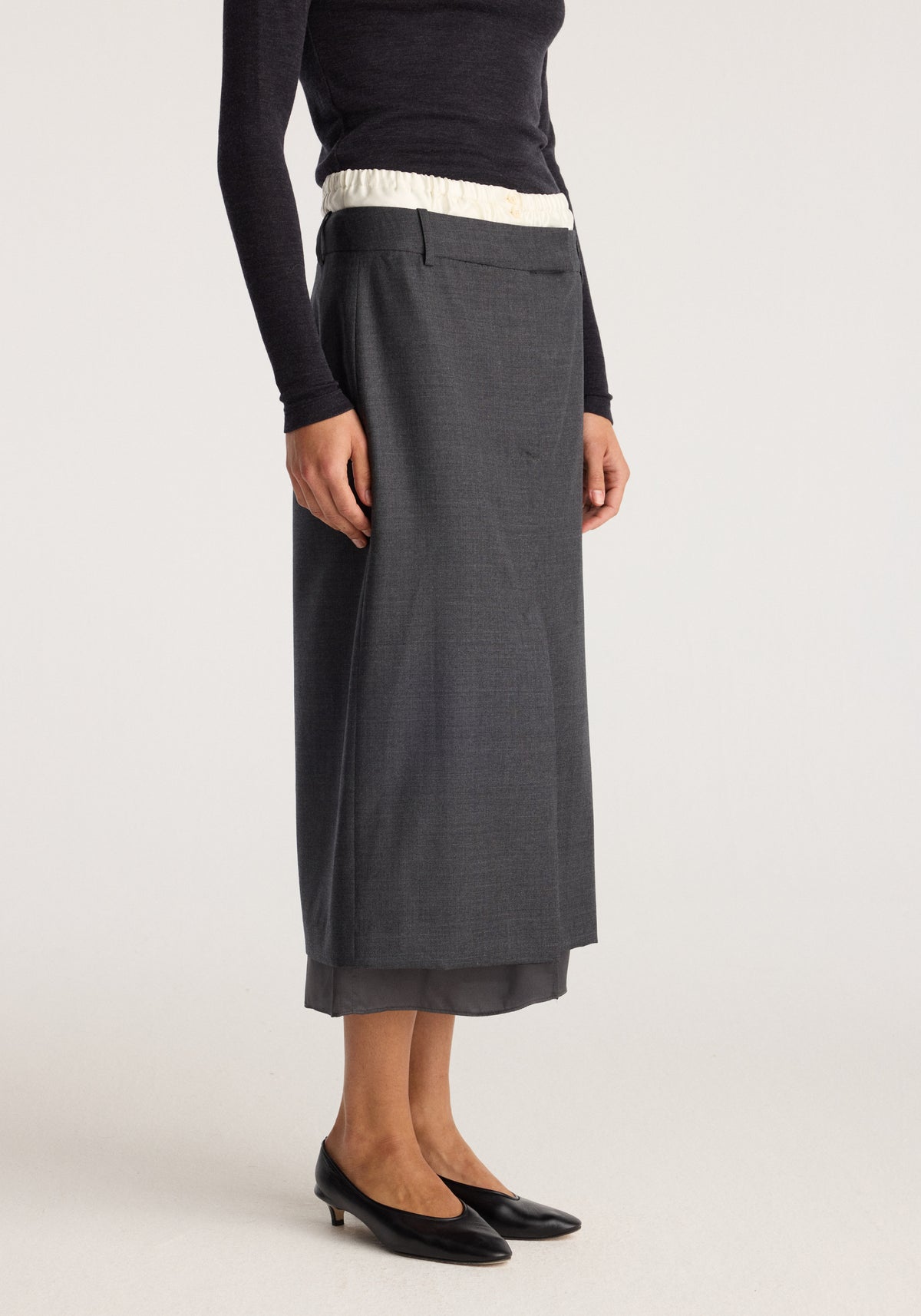 Boxer detailed skirt | dark grey melange worn by a model with a layered hem and black ballet flats