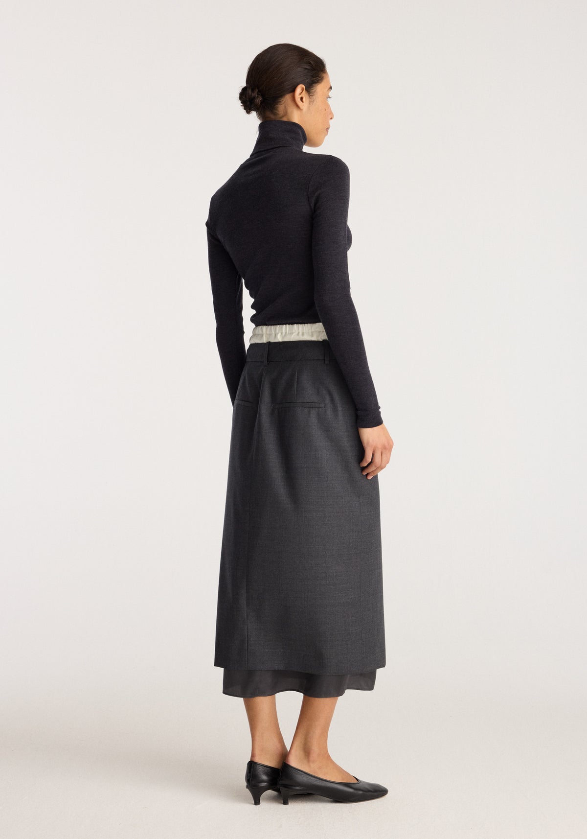 Boxer detailed skirt | dark grey melange shown from the back on a model with a long straight silhouette and subtle checked texture.