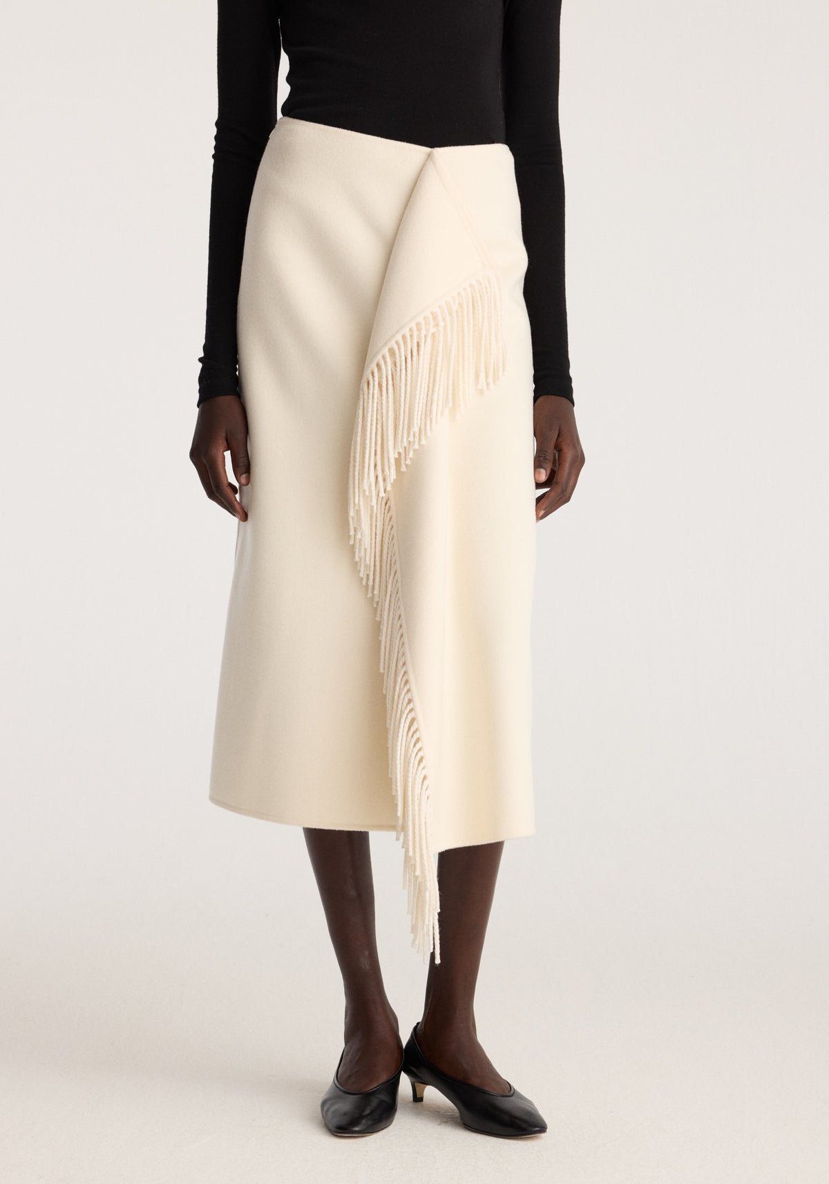 Double-faced fringe skirt | off white worn with a black long sleeve top and black flats showing draped fringe detail on the front panel