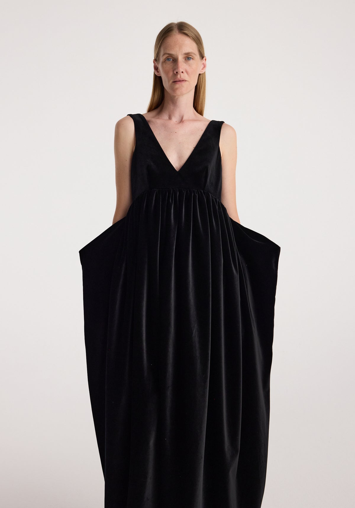 Sculptural volume velvet dress | black shown on a model with a deep V neck, sleeveless design, gathered waist, and dramatic voluminous skirt