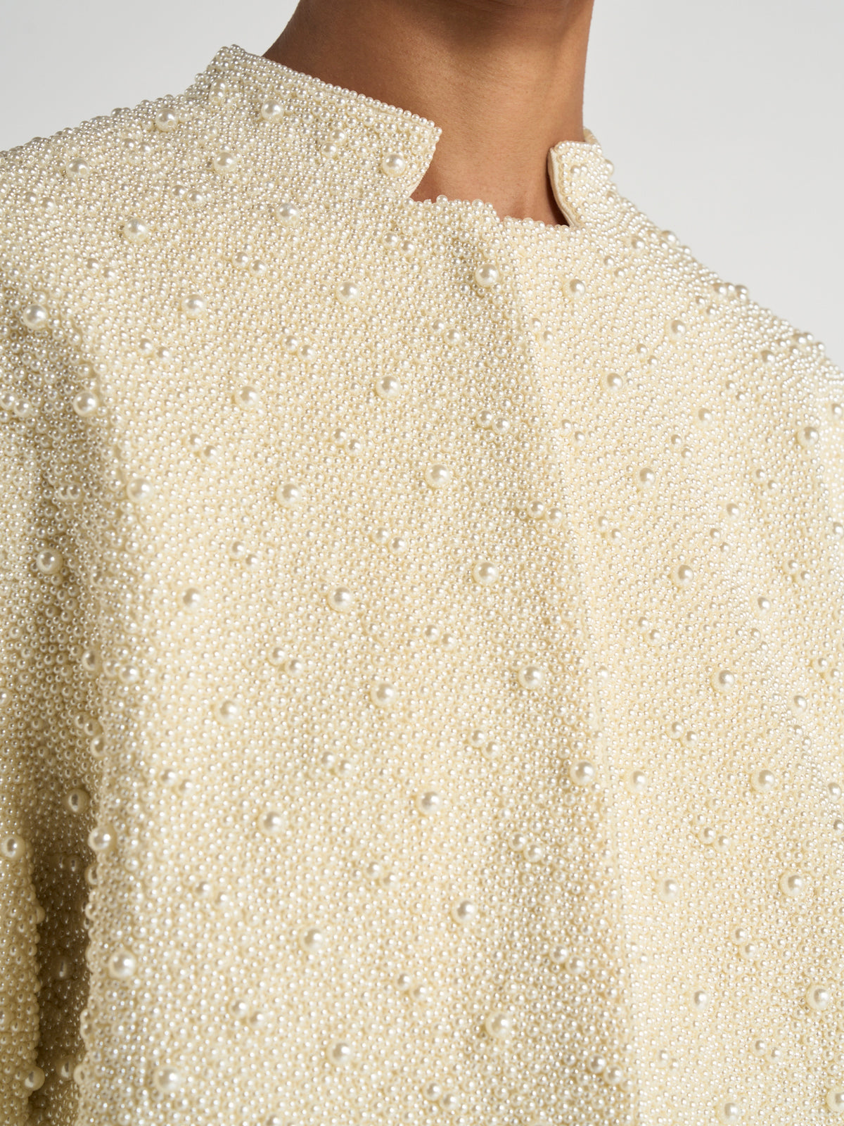 Close-up of a cream jacket covered in hand-beaded pearls, featuring a high collar and delicate pankou detailing. Hand-beaded pearl pankou jacket | pearl