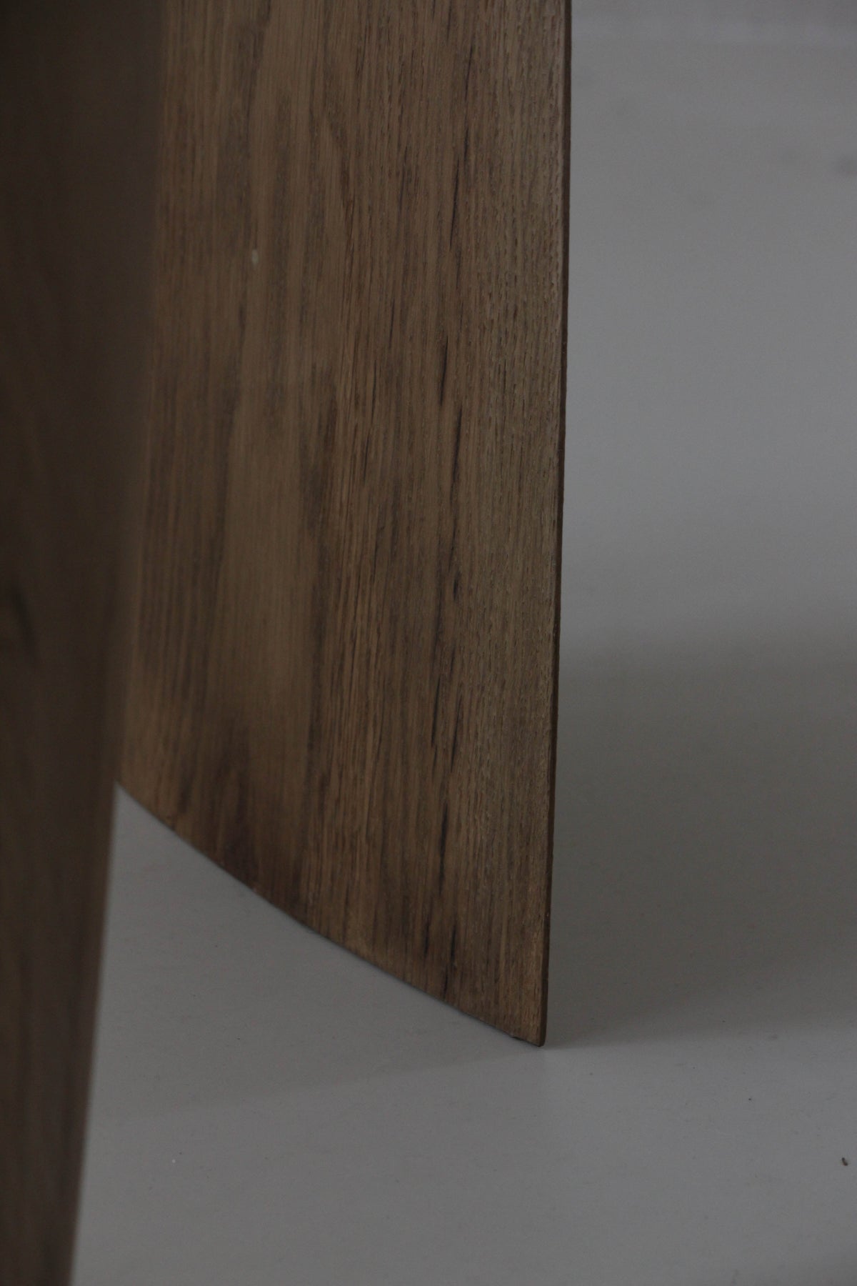 Sculpted Stool | 4673: Close-up of a handcrafted oak stool with visible wood grain and a slightly beveled edge, standing on a light floor.