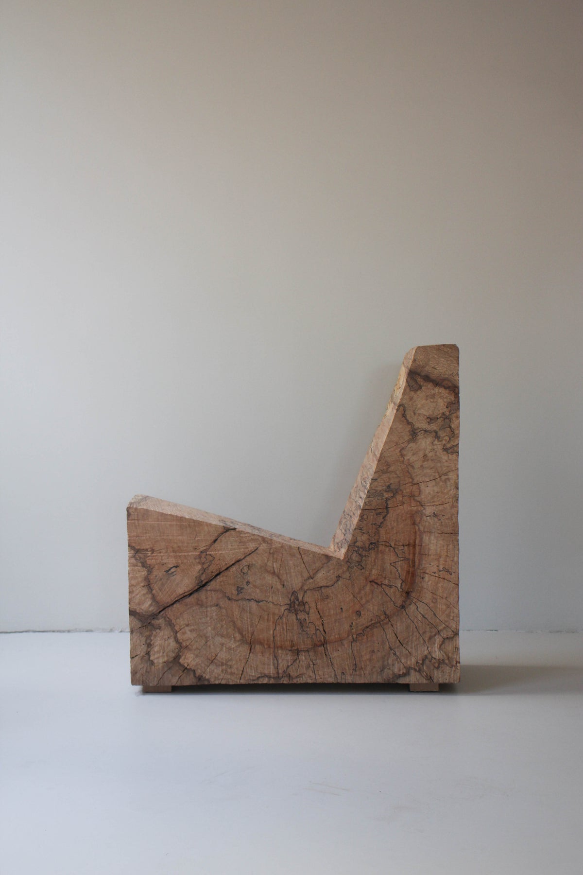 Brutalist Chair | 5788, an L-shaped bench carved from oak by Arne Kristian, showcasing raw grain and saw cuts, blending sculpture with functionality.