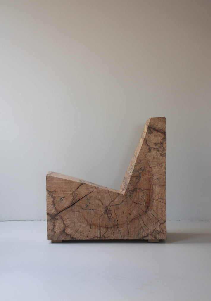 Brutalist Chair | 5788, an L-shaped bench carved from oak by Arne Kristian, showcasing raw grain and saw cuts, blending sculpture with functionality.