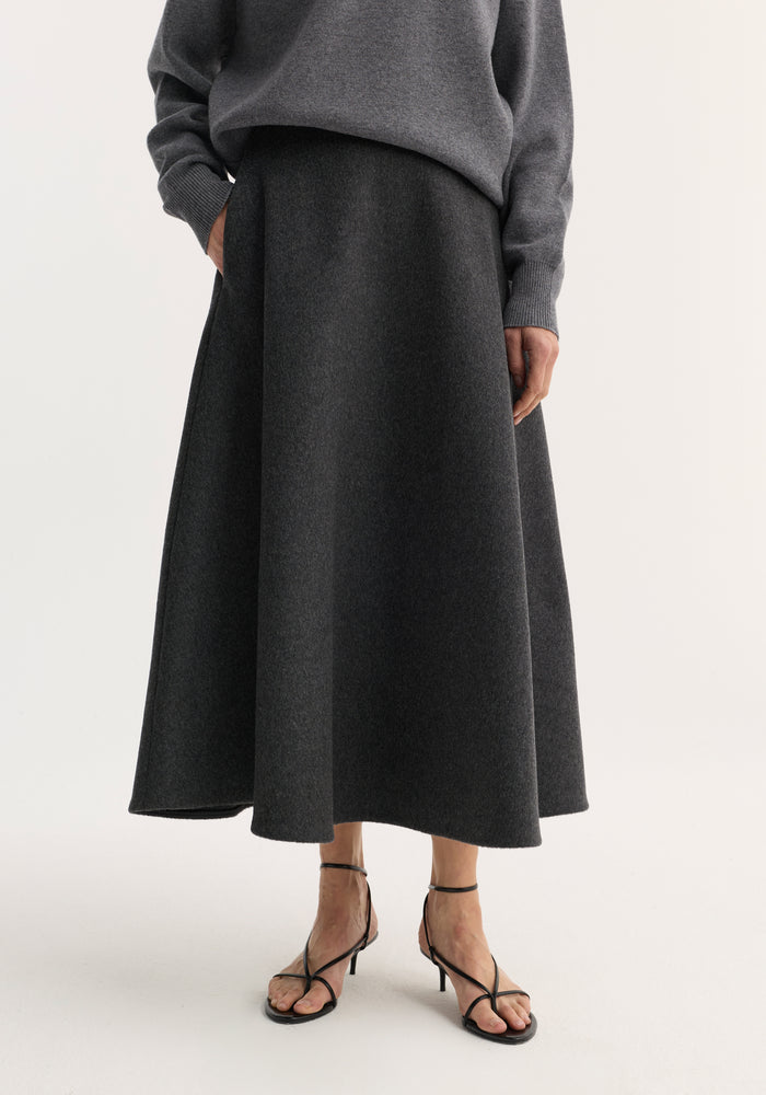 A-line skirt | anthracite melange: Charcoal-gray, A-line midi skirt with side pockets, paired with black heel sandals and a grey sweater.
