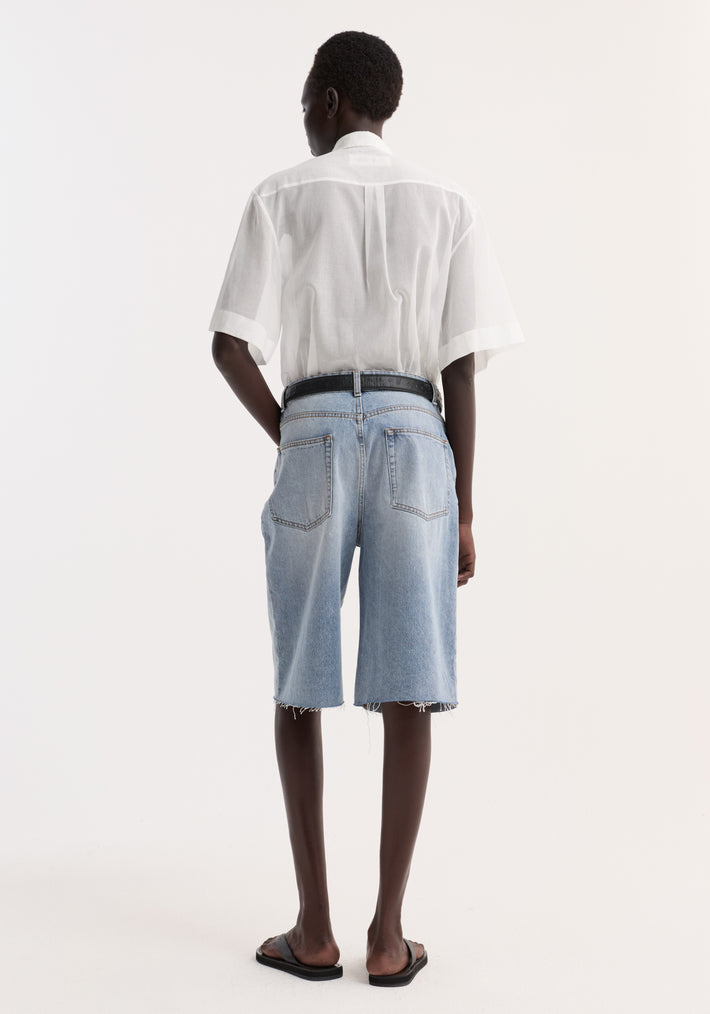 Back view of a model wearing the Embroidered muslin shirt in optic white, featuring drop short sleeves, covered buttons, and delicate collar embroidery.