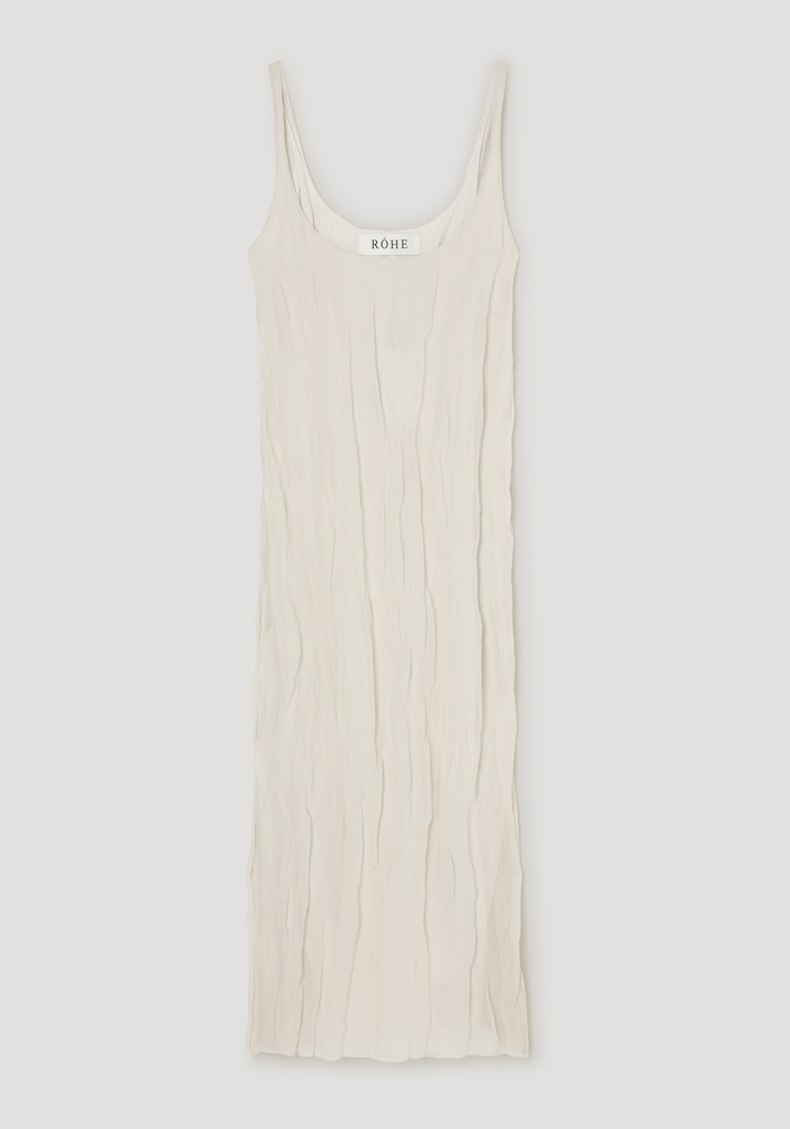 Textured square neck dress in cream with spaghetti straps, subtly crinkled fabric, and a scooped neckline, featuring a unique shapeable metallic yarn blend.