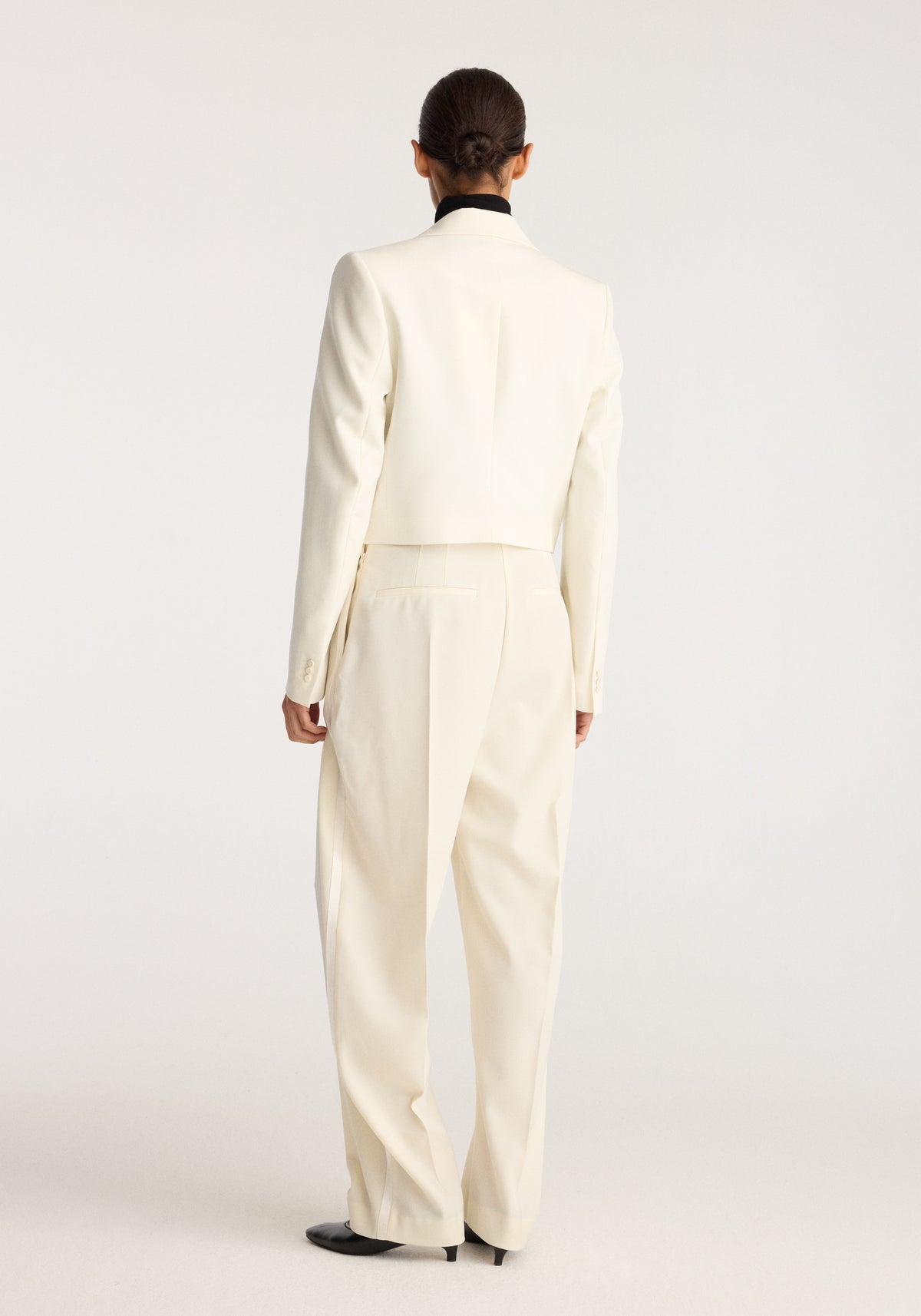 Cropped blazer | off white shown from the back on a model, featuring a tailored fit, long sleeves, and a cropped hem.