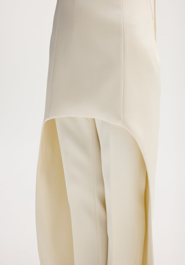Ivory satin bustier dress with train, featuring bustier-style stitching, adjustable straps, and elegant asymmetrical draping over tailored trousers, creating a sophisticated ensemble.