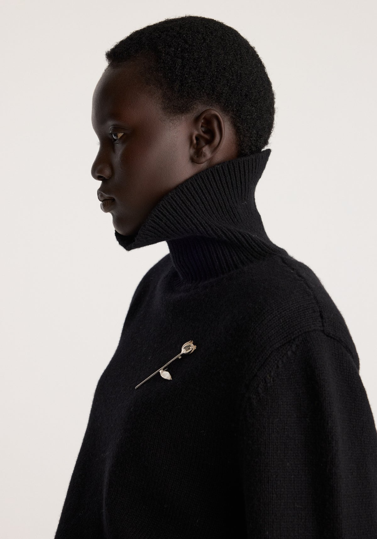 Tulip silver brooch | silver worn on a black turtleneck sweater showing its delicate tulip shape against dark fabric