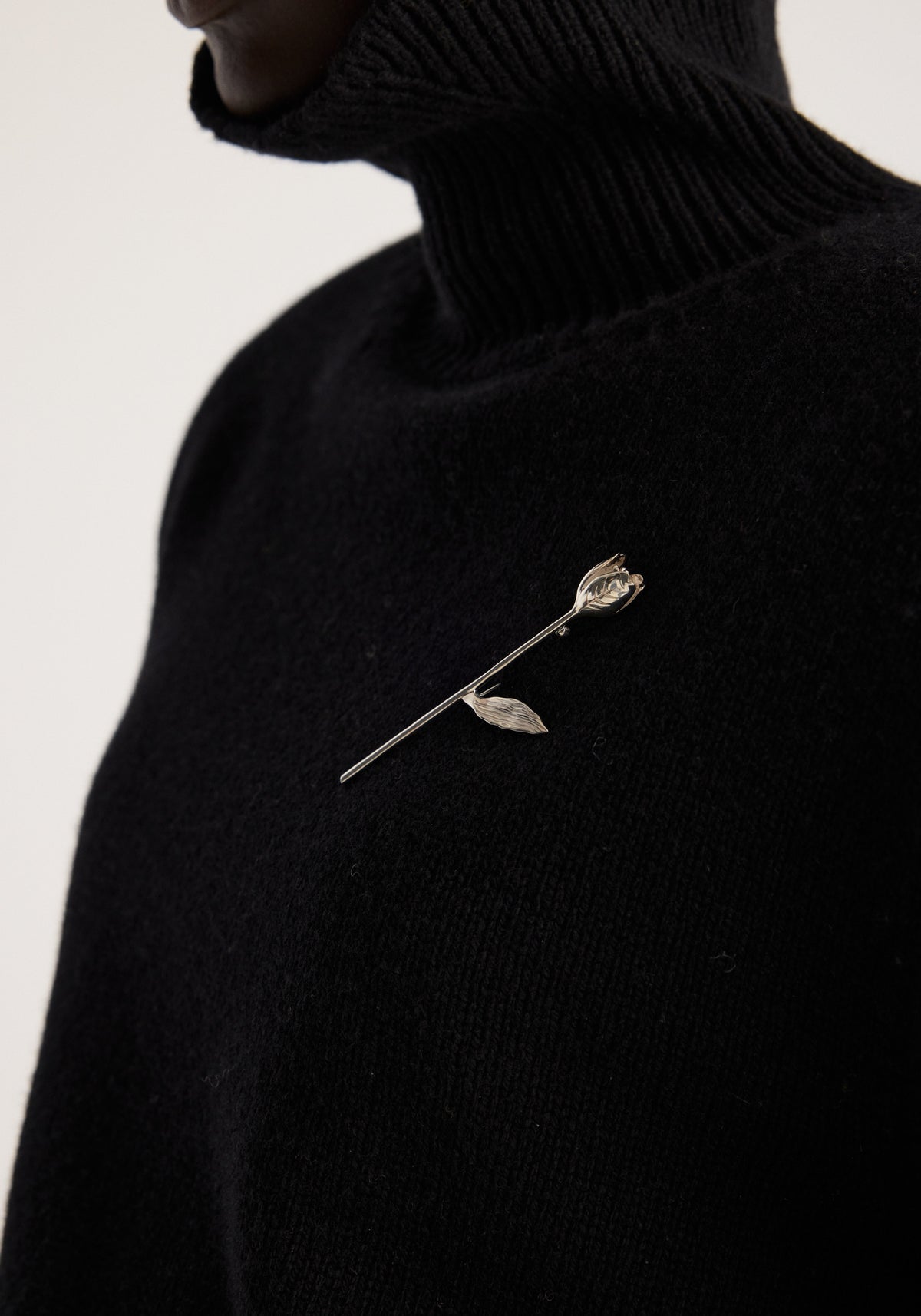 Tulip silver brooch | silver featuring a delicate tulip flower design pinned to a black knit sweater