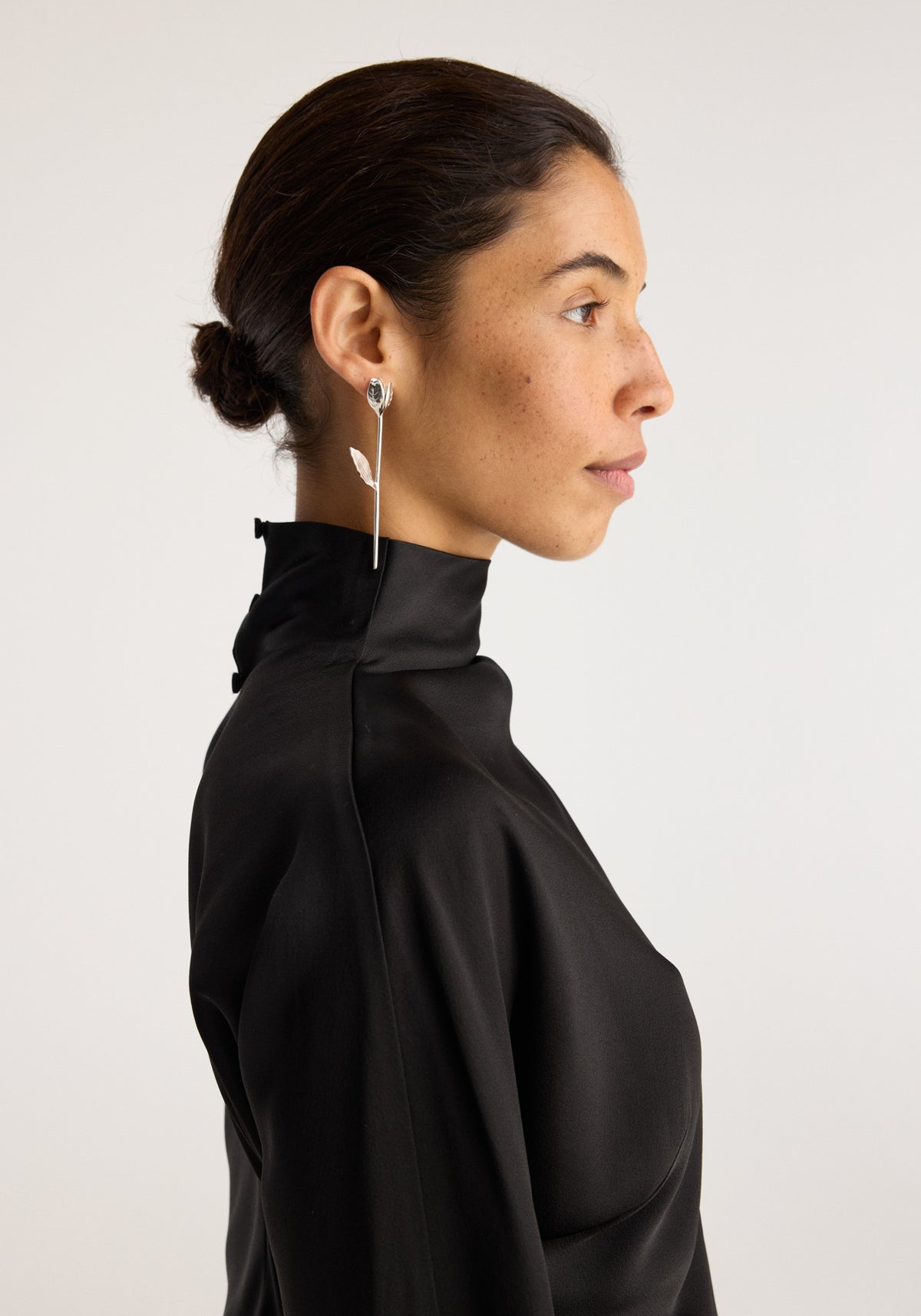 Tulip silver earrings (pair) | silver shown on a model with a delicate tulip shaped drop earring visible in profile against a light background