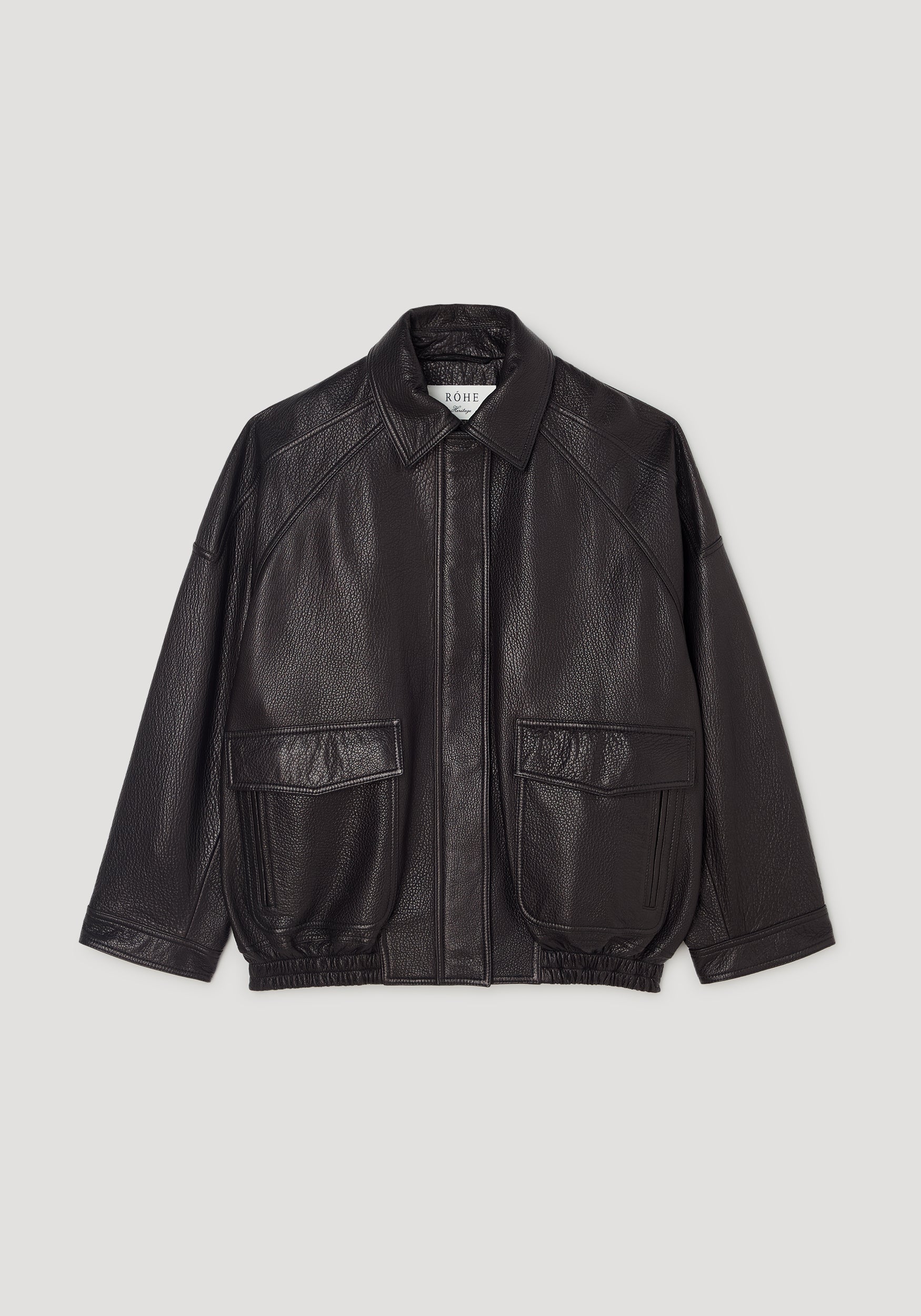Black grain leather aviator jacket with a wide collar, front flap pockets, long sleeves, and elasticated hem, designed in a classic, slightly oversized silhouette. Grain leather aviator jacket | black.