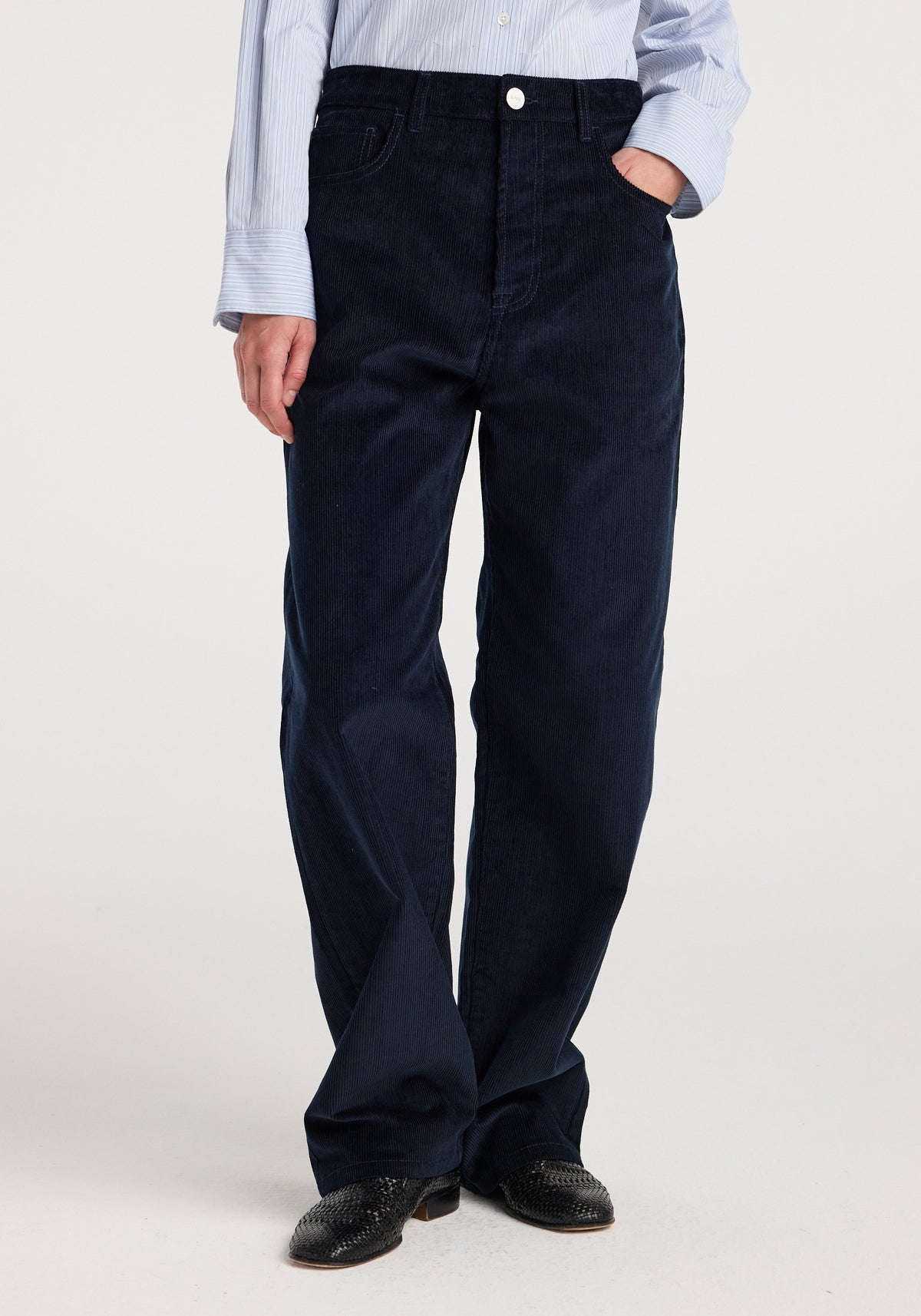 Bruun - Signature baggy corduroy | night, model wearing relaxed dark navy corduroy trousers with a light blue shirt and black shoes