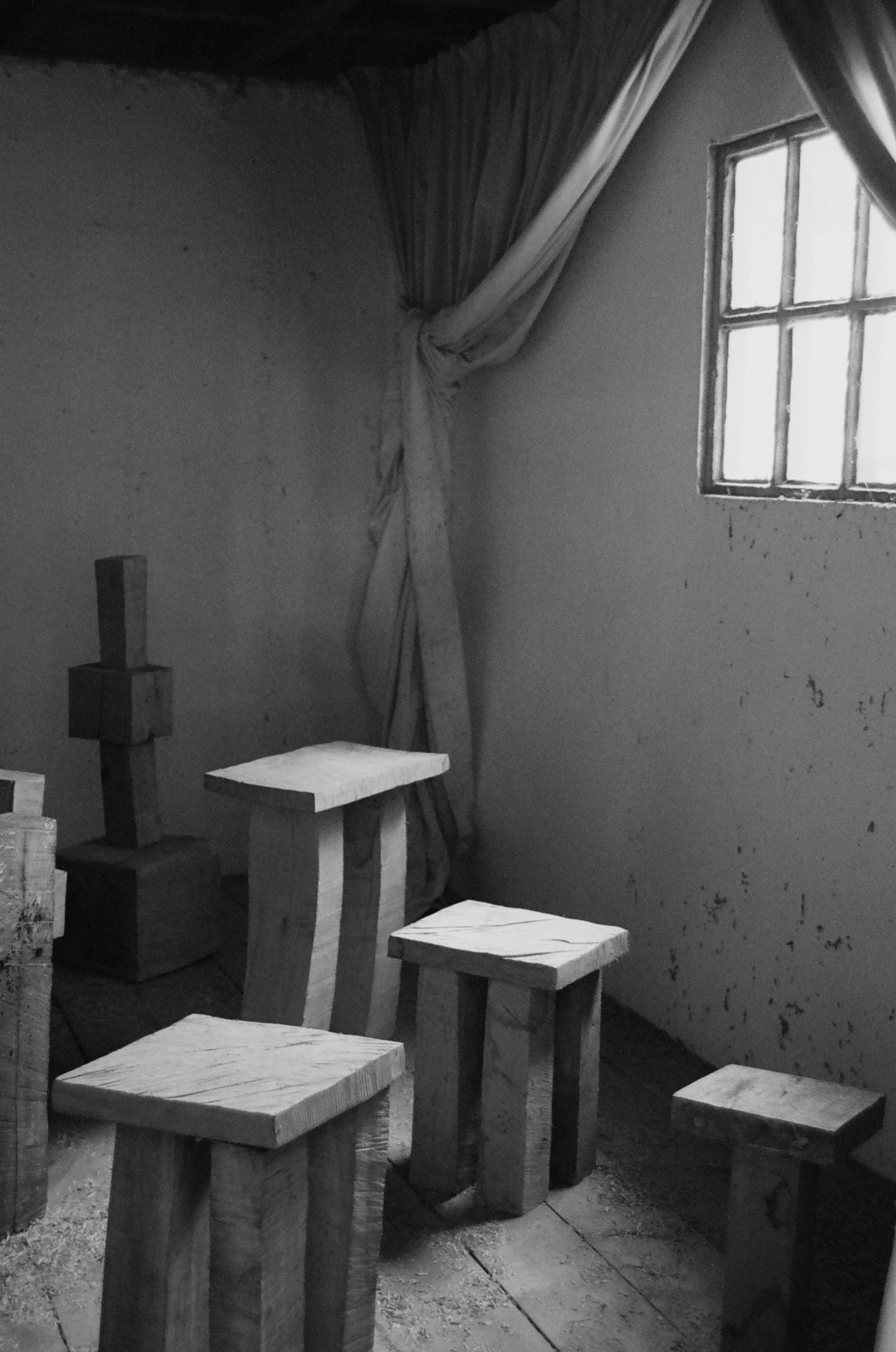 Black and white room with square wooden stools and a window.
