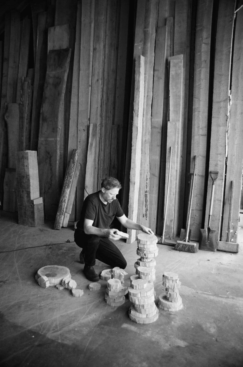 Person building a tower with wooden blocks in a workshop.