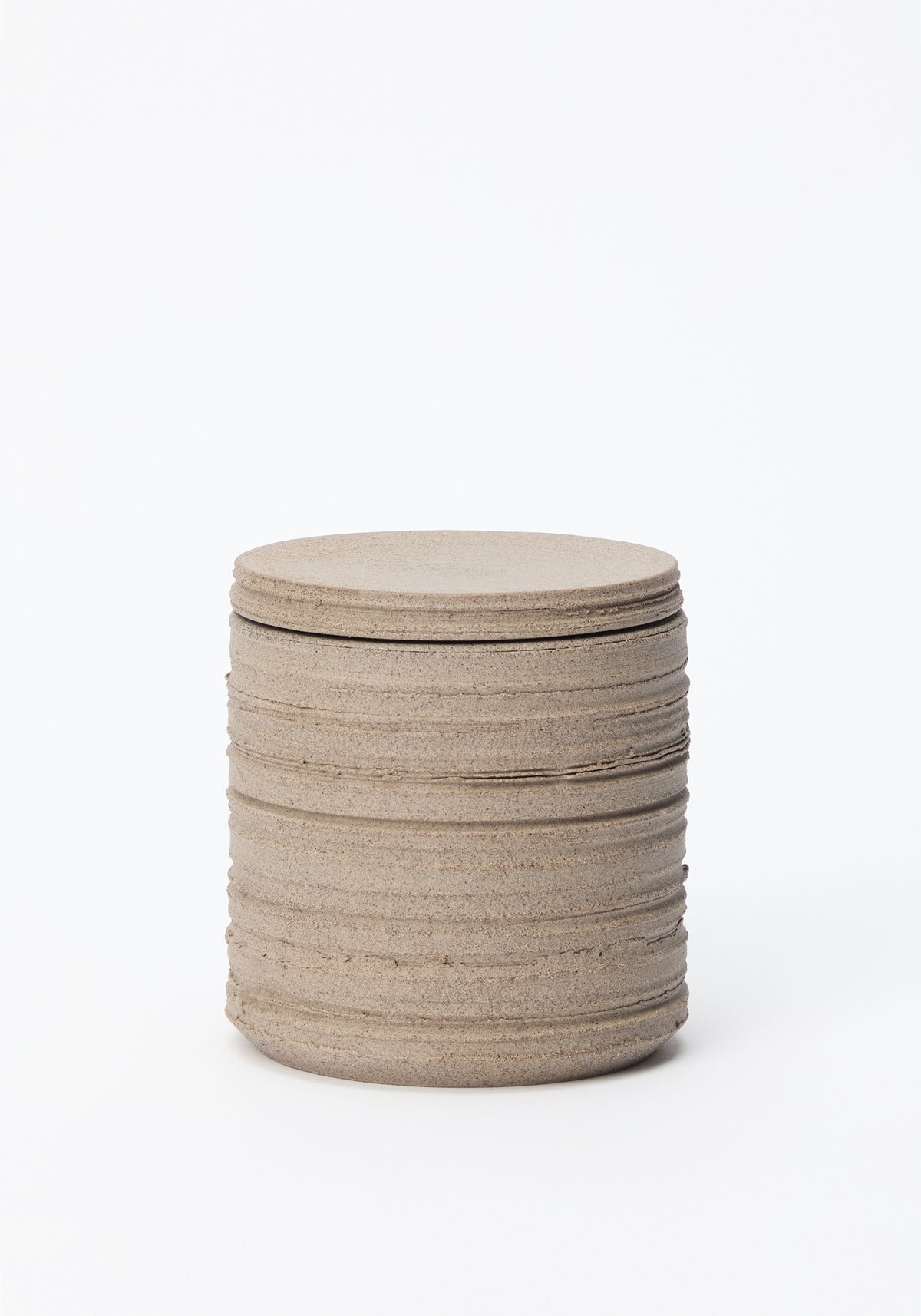 Minimalist textured stone container with a round lid, designed for the Diplomatico Scented Candle | stone, featuring natural earthy tones and a rustic finish.