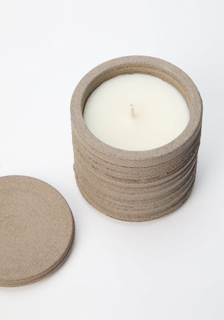 Diplomatico Scented Candle on woven mat, showcasing thin, light-brown pads. Ceramic vessel by Alex Gabriels, designed for reuse, with a woody-aromatic fragrance.