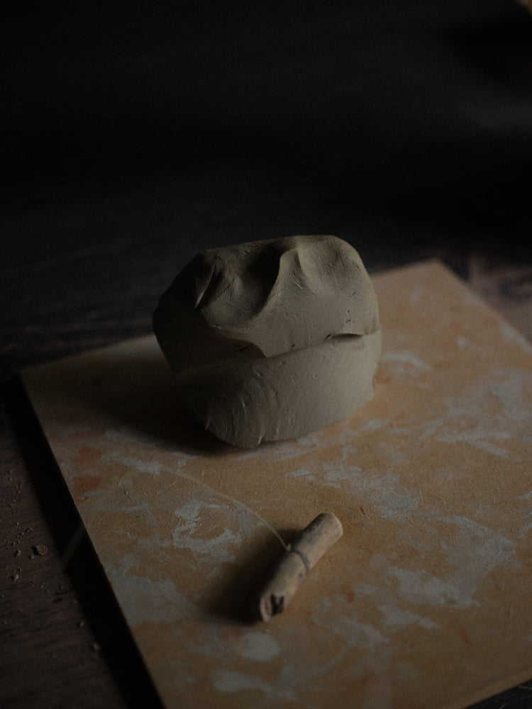 Piece of clay on a textured surface with a dark background