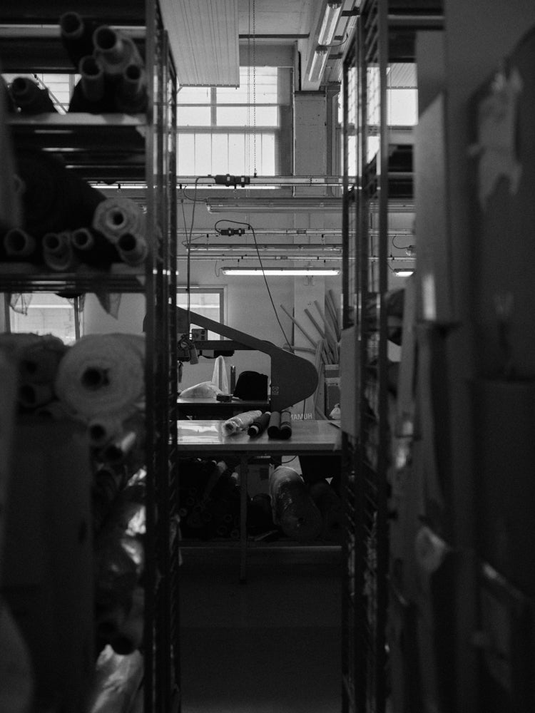 Indoor setting with shelves and rolls of fabric, in a knitwear factory