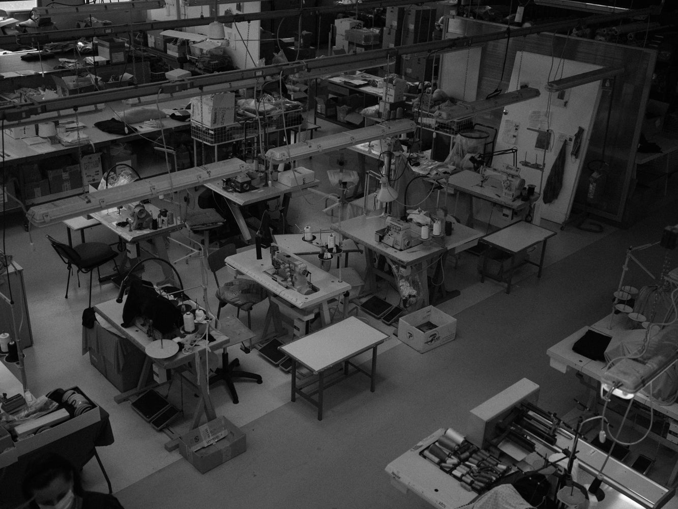 Black and white aerial view of a busy workshop with various tools and equipment.