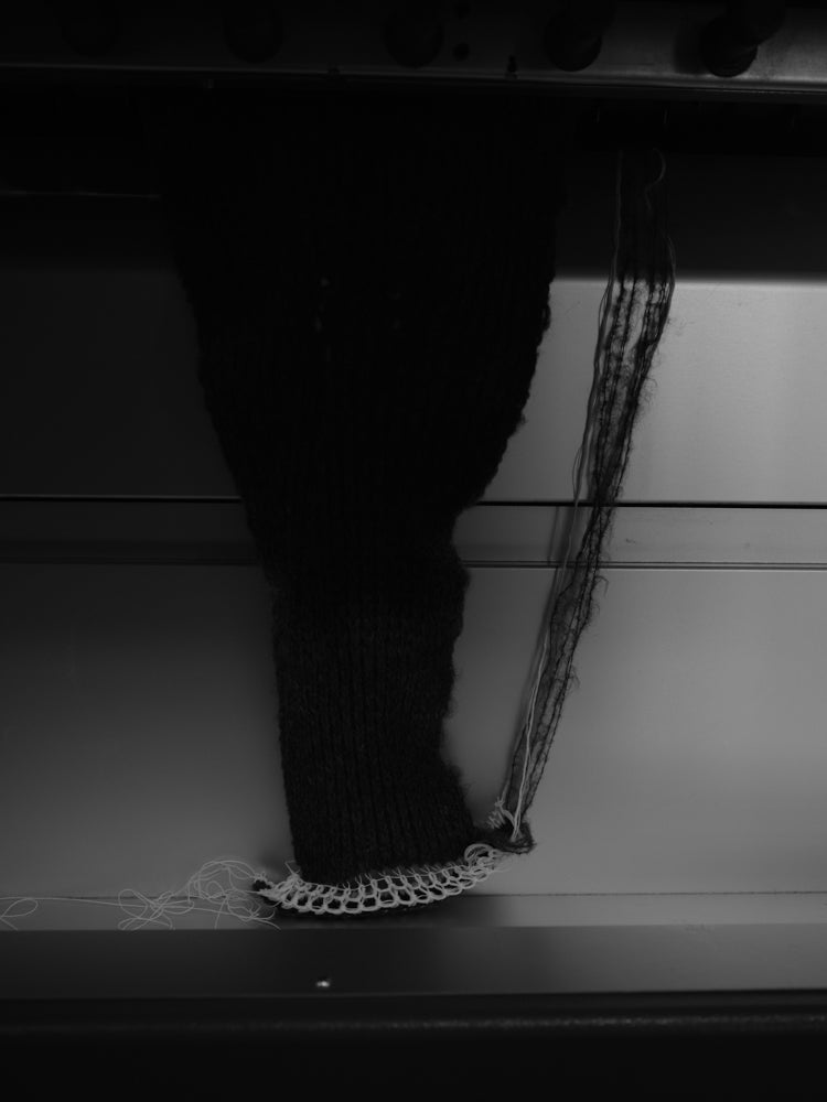 Knitted sleeve coming out of a knitting machine